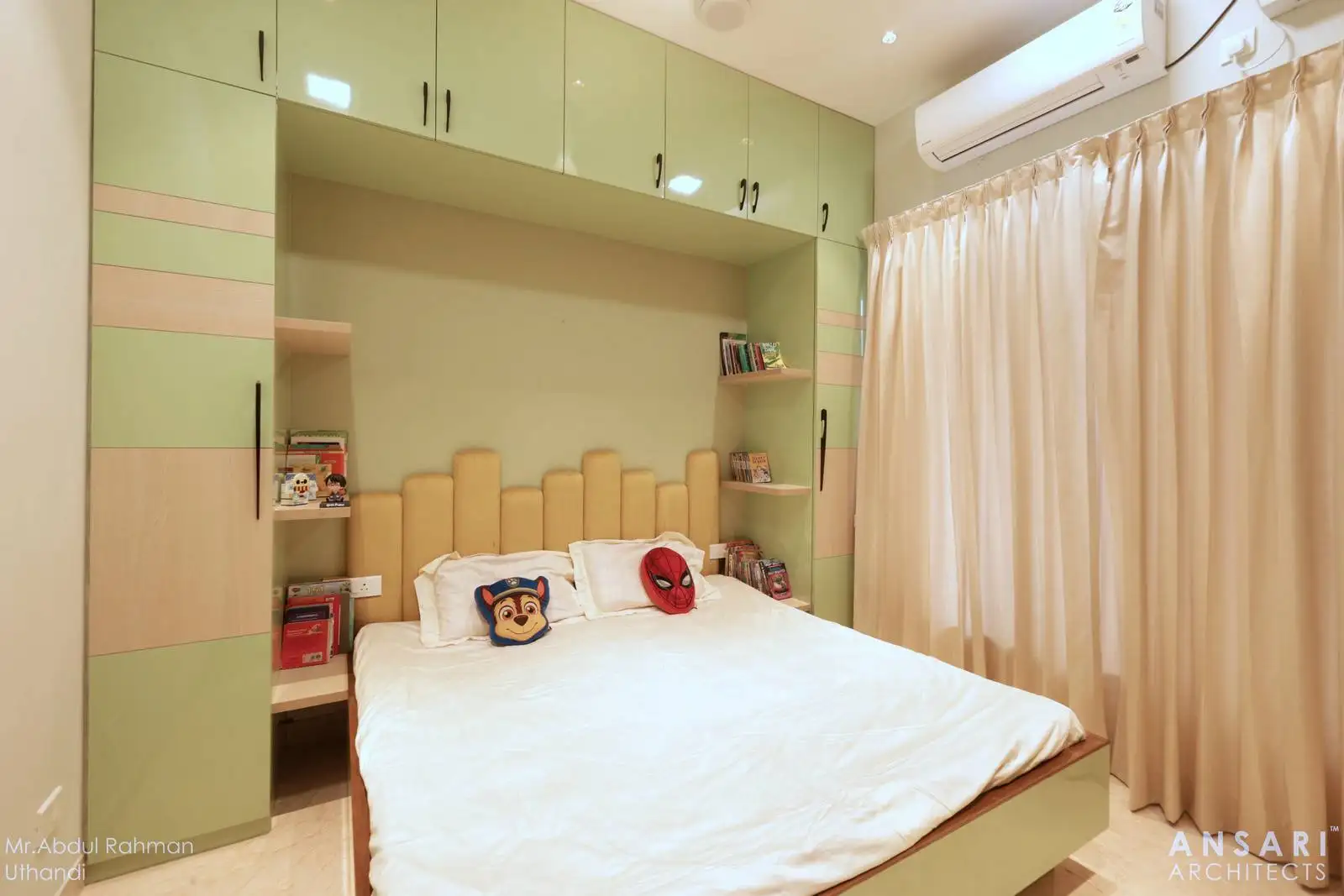 A compact kid’s room with a centrally placed bed, custom cabinetry, and open shelves for easy access to books and toys.