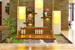 Indoor wooden swing suspended by ornate golden chains in a stylish room with stone accent wall, illuminated floral shelves, green potted plant on the left, and marble flooring.