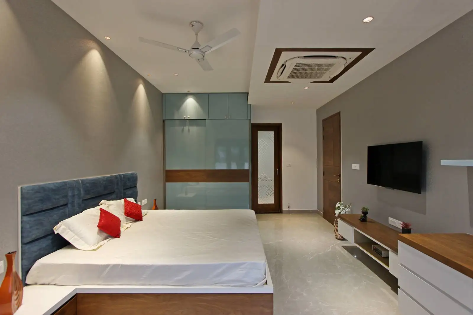 Built-in wardrobes and a window seat maximize storage, with the entrance door positioned opposite for balanced flow.
