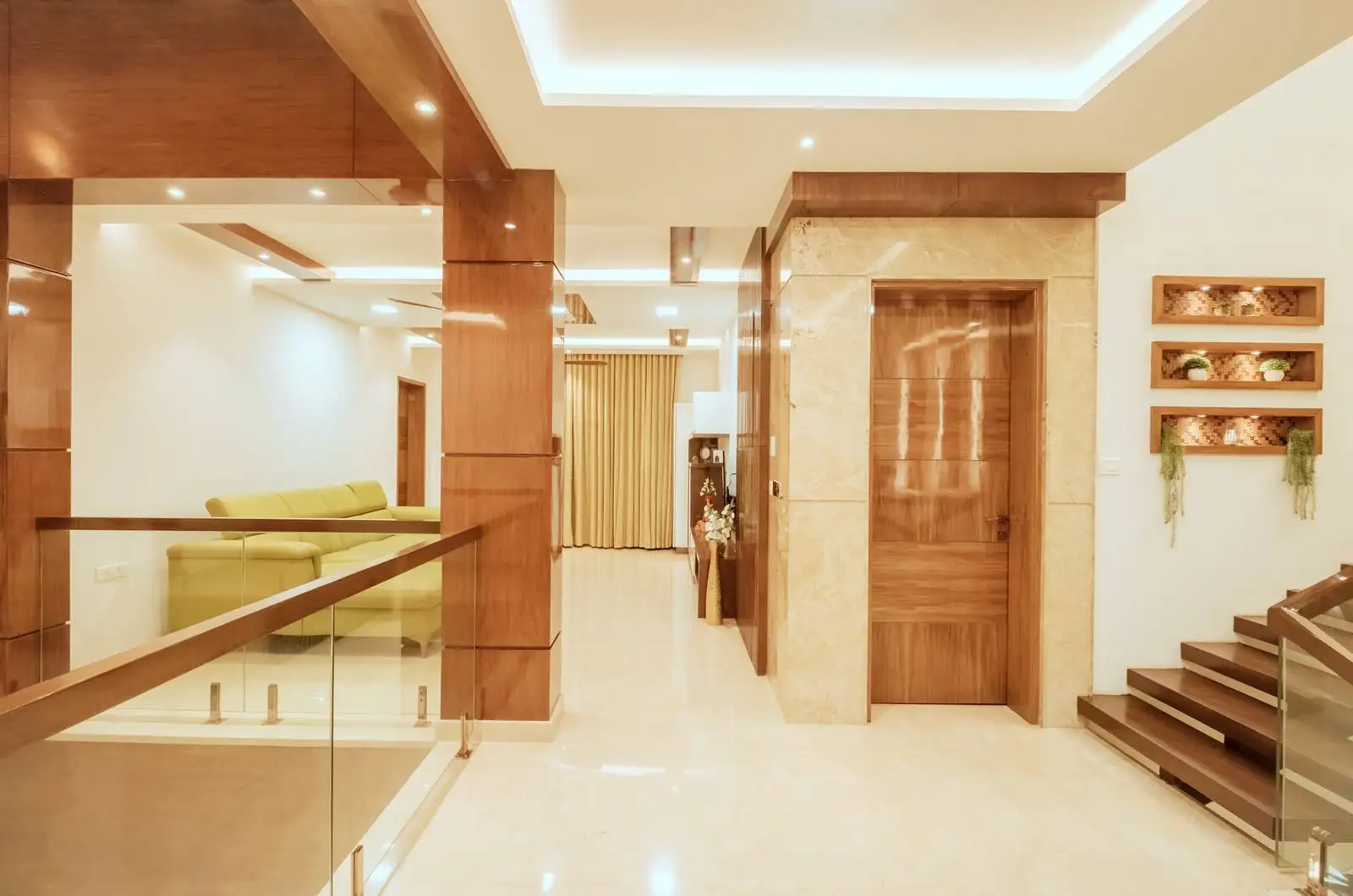 First-floor family lounge with rich wooden paneling and a staircase combining wooden treads and glass balustrades for timeless elegance.
