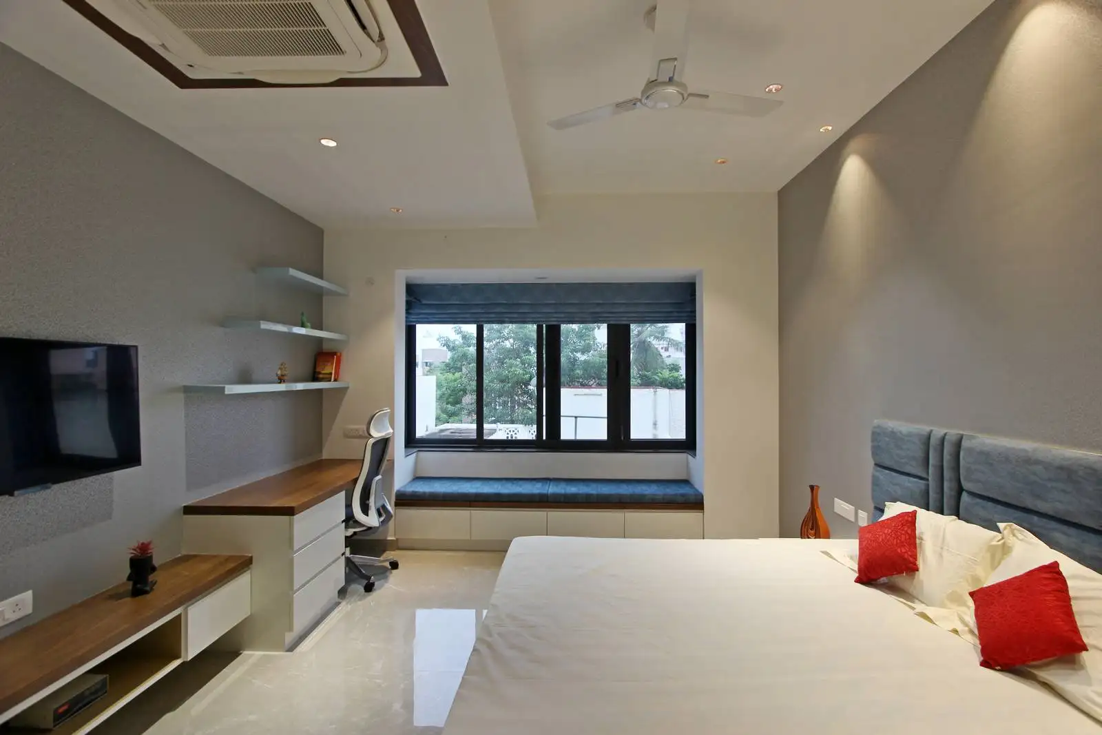 The study area features a wooden desk with white drawers and floating shelves for efficient storage.
