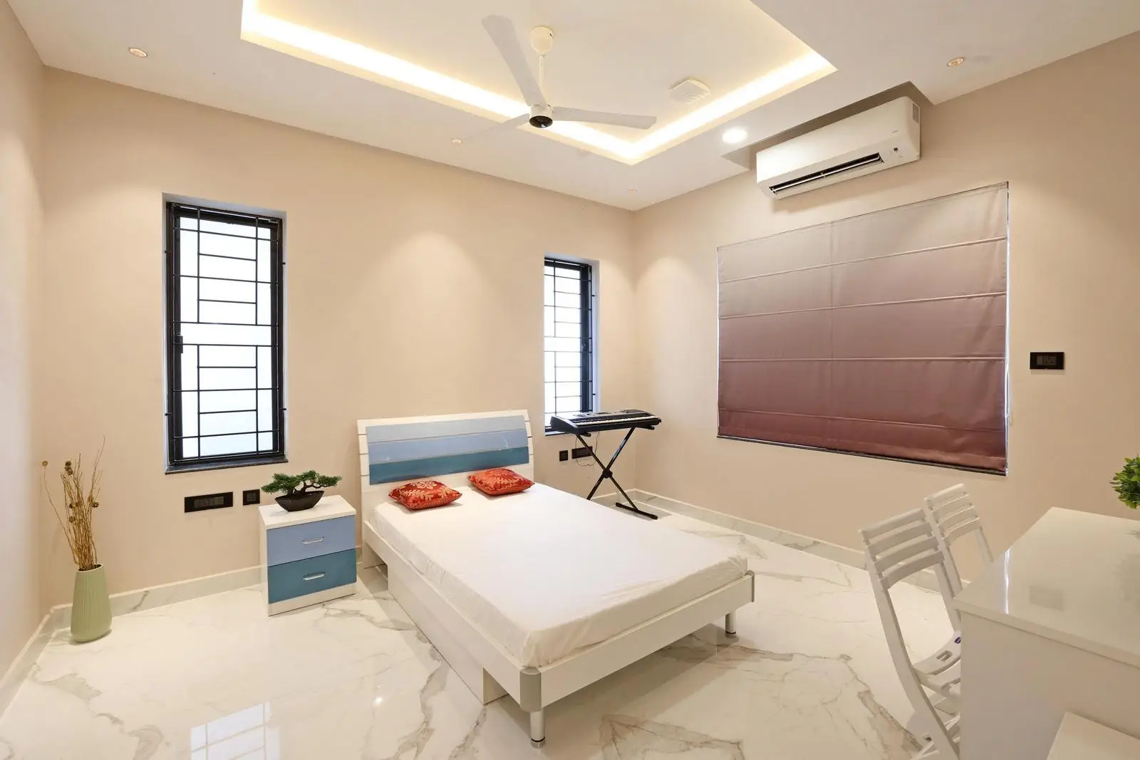 Bedroom 2 for the second daughter both feature open, symmetrical layouts with central beds and study areas by the windows. White marble floors, beige walls, and pastel furniture create bright, youthful spaces. Layered lighting and minimal furnishings keep both rooms functional, modern, and airy.