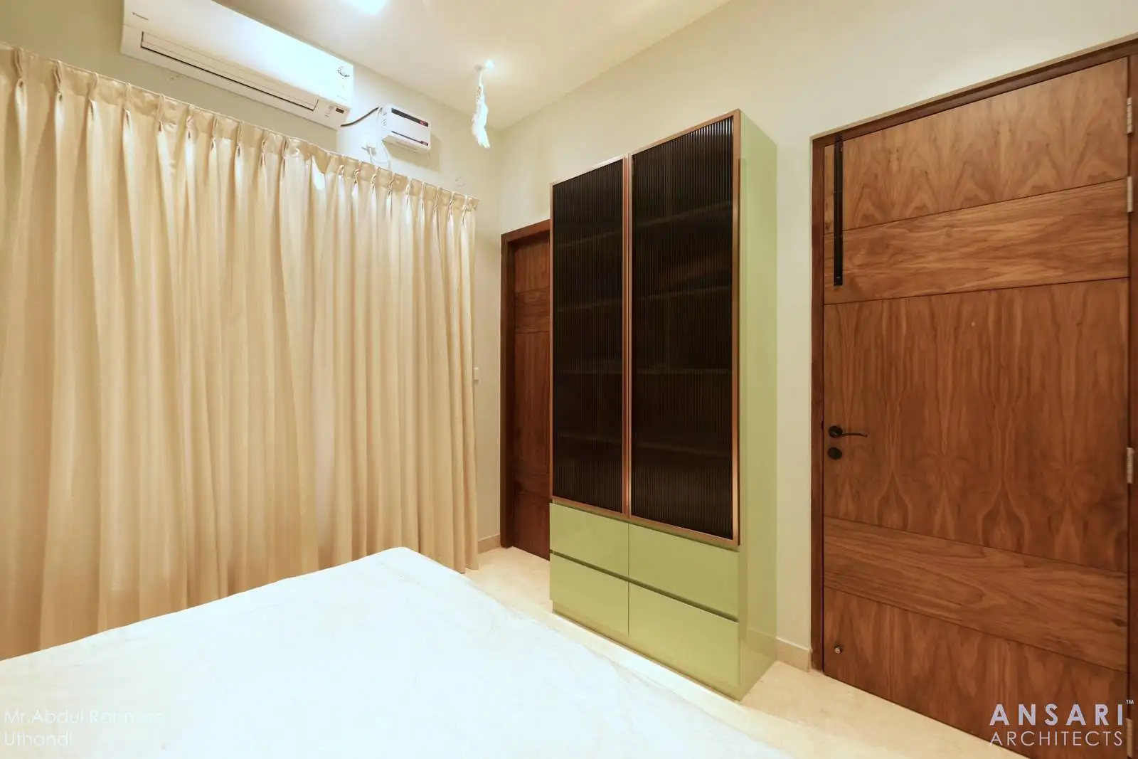 The window is generously sized, allowing for plenty of natural light, and is dressed with full-length beige curtains for privacy and softness.