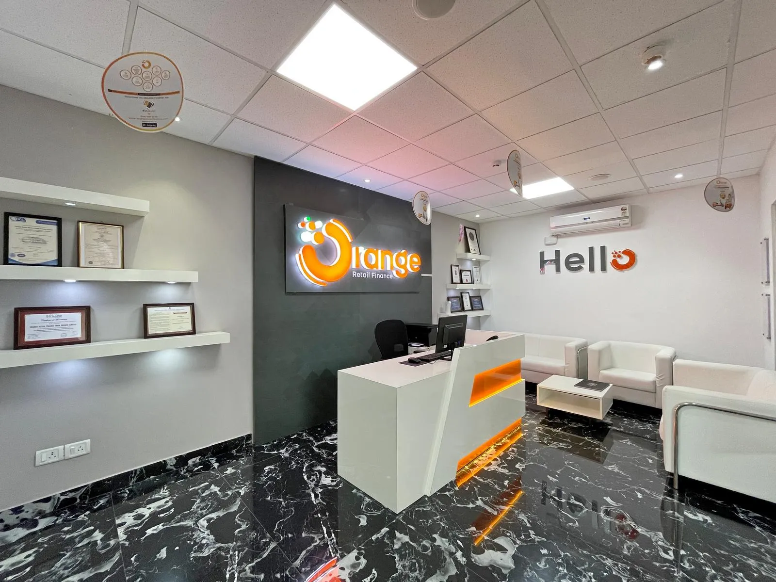 The second-floor reception combines sleek geometry, polished marble flooring, and branded accents to create a professional yet welcoming environment.