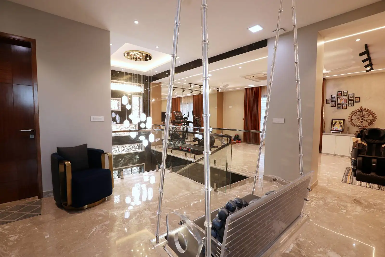 Open first-floor family area with glass railings, offering views to the double-height living below and promoting light, connection, and safety.