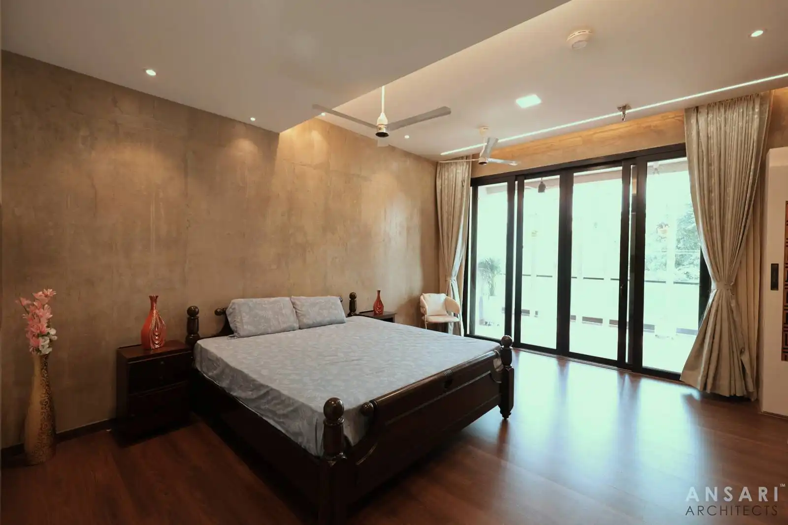 Large sliding glass doors in the bedroom connect seamlessly to the balcony, enhancing natural light and views while supporting an indoor-outdoor living experience. Drapes provide flexible control over light and privacy.