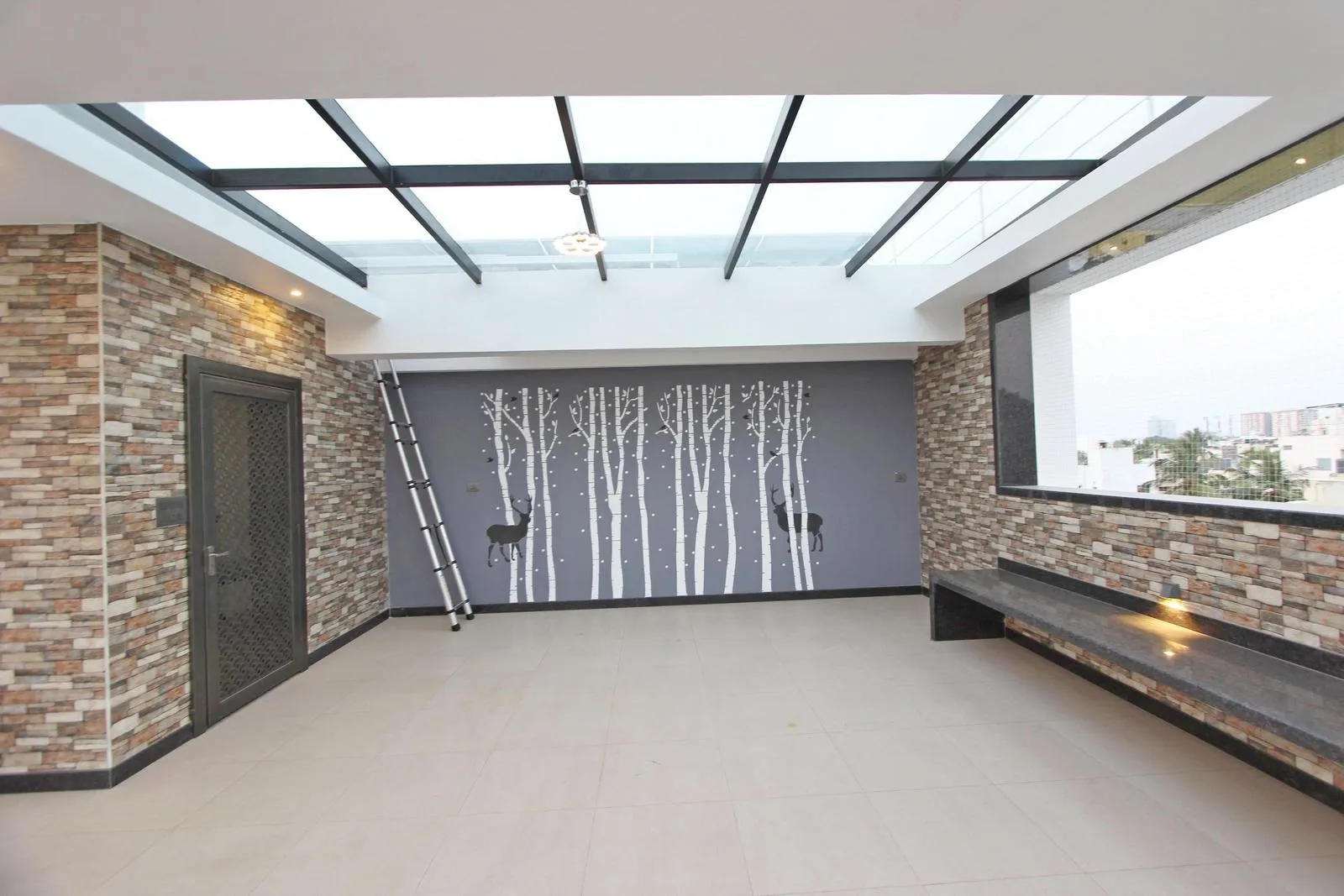 The terrace has a rectangular layout with a grey feature wall and built-in seating, creating a calm, flexible space. The seating maximizes comfort and efficiency, while the clean lines maintain balance and allow versatile use.