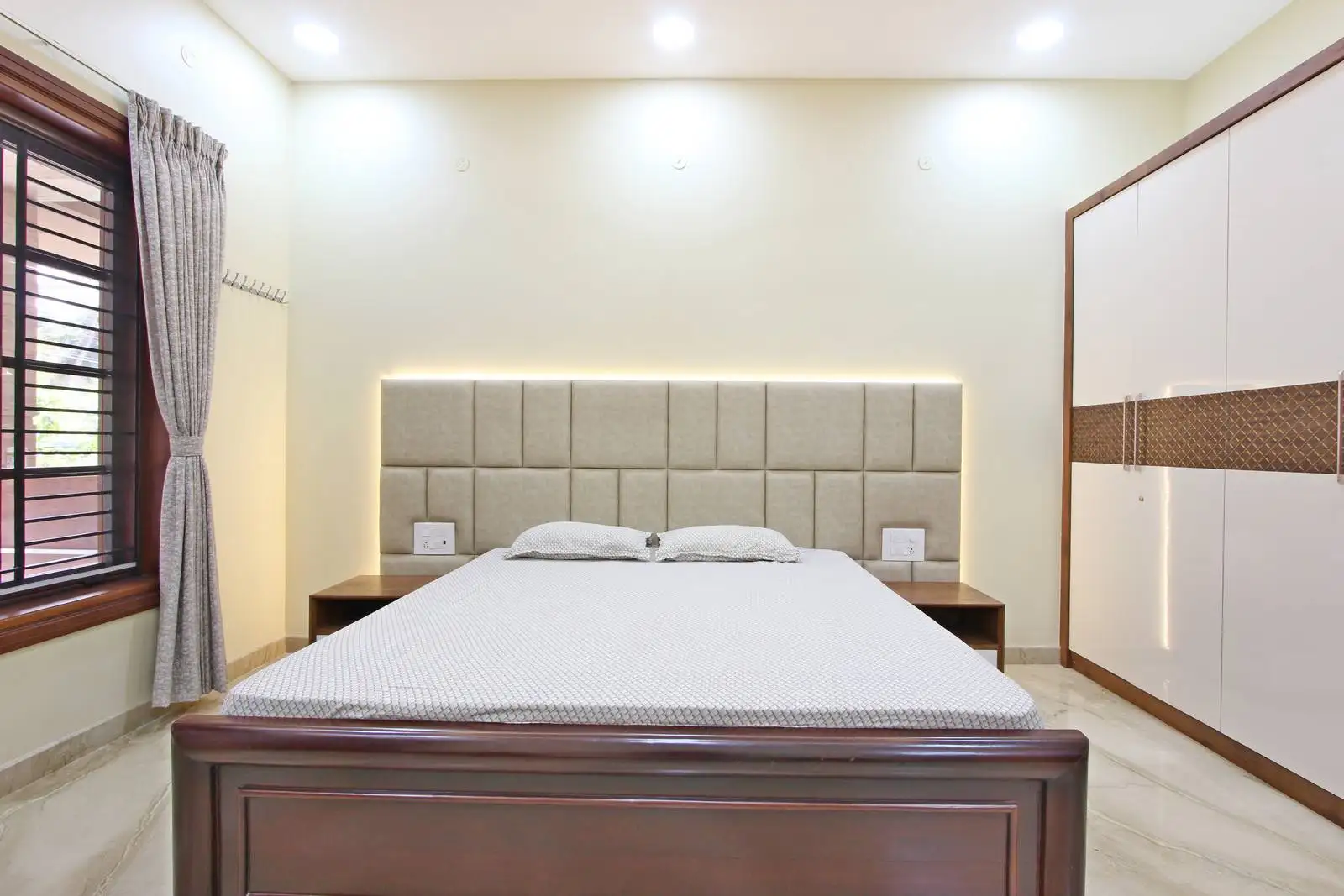 Thoughtfully designed bedroom with ample natural light, practical storage, and elegant window treatments for comfort and style.