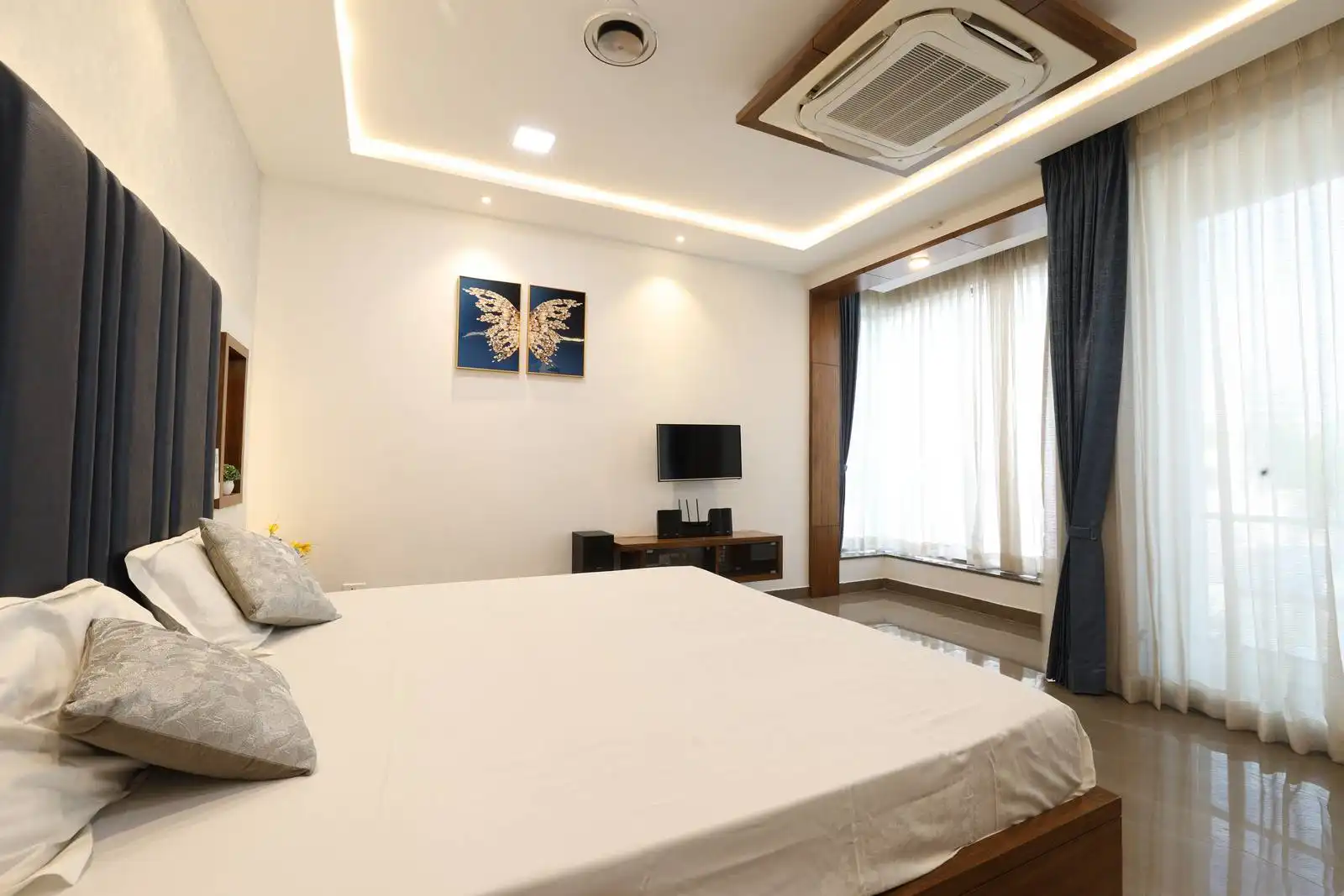 The window is framed with wood, and the use of sheer and blackout curtains allows for flexible light control and privacy.