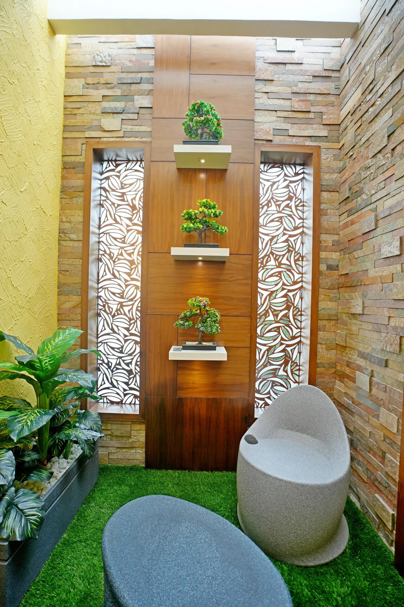 This compact courtyard ( 8'0" x 7'0" ) features a vertical garden, sculptural seating, and layered greenery, using natural stone, wood, and patterned glass to create a calm, light-filled retreat.