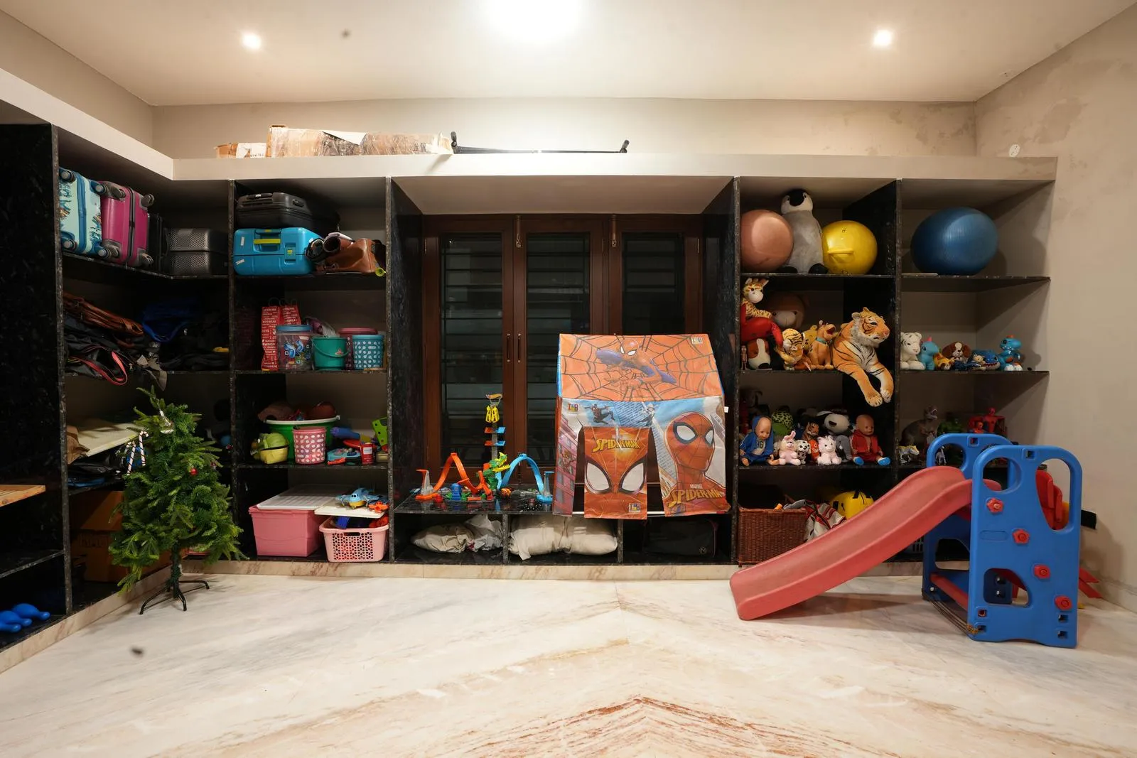 The second-floor playroom (19'6" x 15'6") is a bright, open recreational space with polished marble flooring and large windows for natural light and ventilation. Built-in shelving maximizes storage while keeping the central area uncluttered, ensuring flexibility for play and activities.