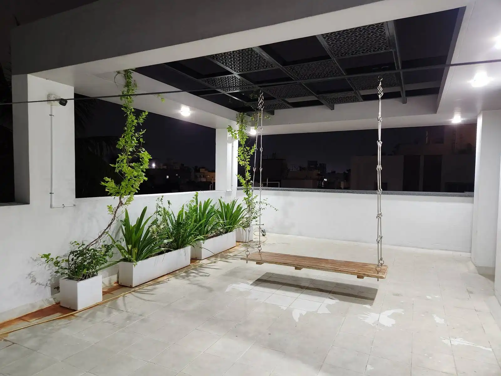 The ceiling currently features a grid-like black panel, providing partial shade and a contemporary look.
