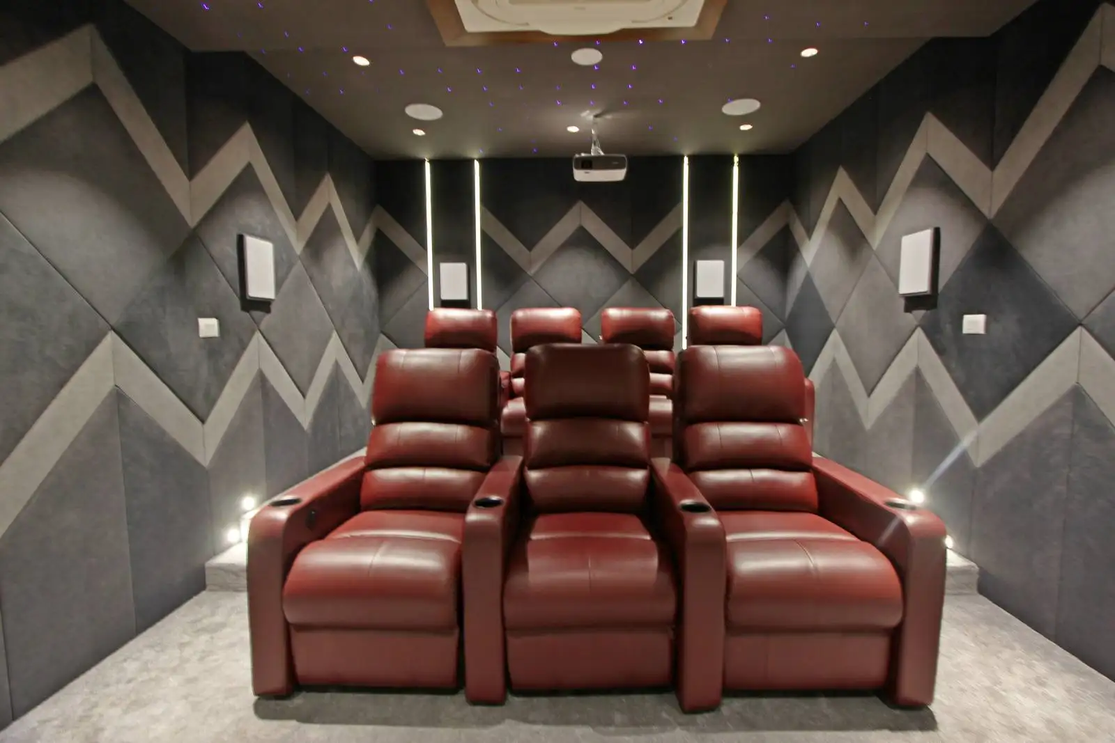 Purposefully designed for immersive viewing, this home theater features tiered red leather recliners and optimized layout to ensure comfort and clear sightlines for all viewers.