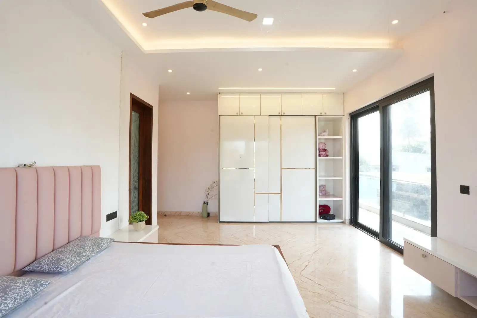 Windows enhance natural light and outdoor connectivity, while layered lighting and premium flooring elevate comfort and style.