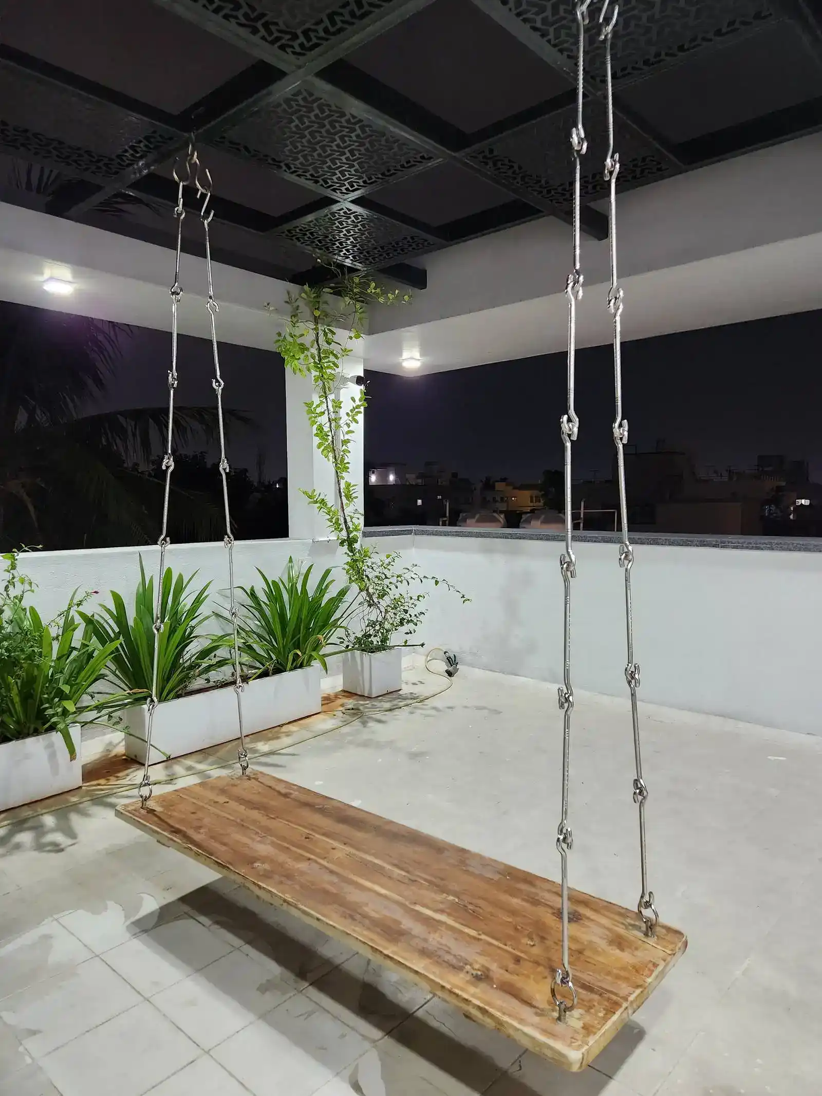 Integrated planters and climbing greenery bring nature in, while a suspended wooden swing serves as a playful focal point.