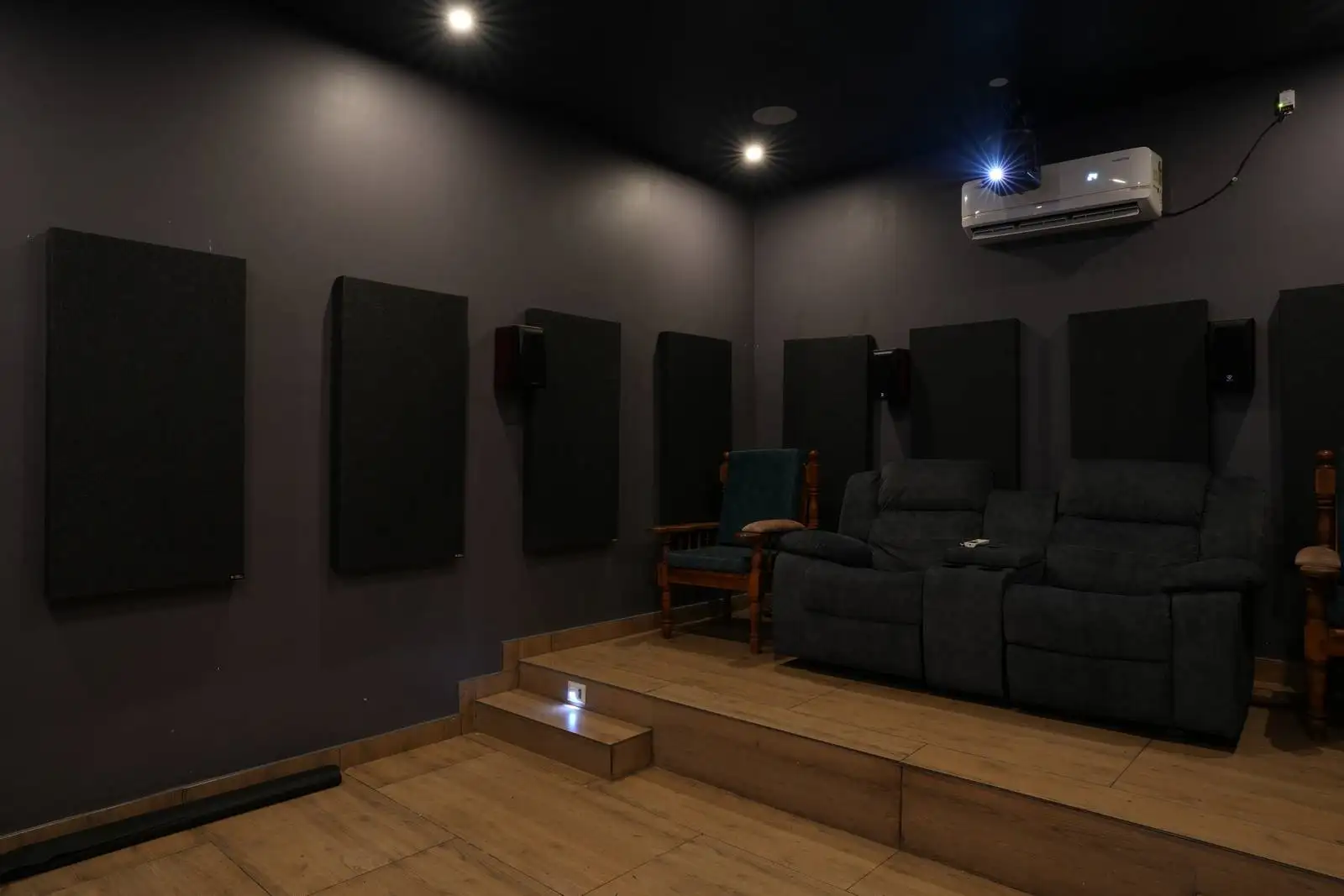 Dark matte walls reduce light reflection, enhancing screen focus for an authentic theater experience.
The subdued color palette creates a cozy, immersive atmosphere.
