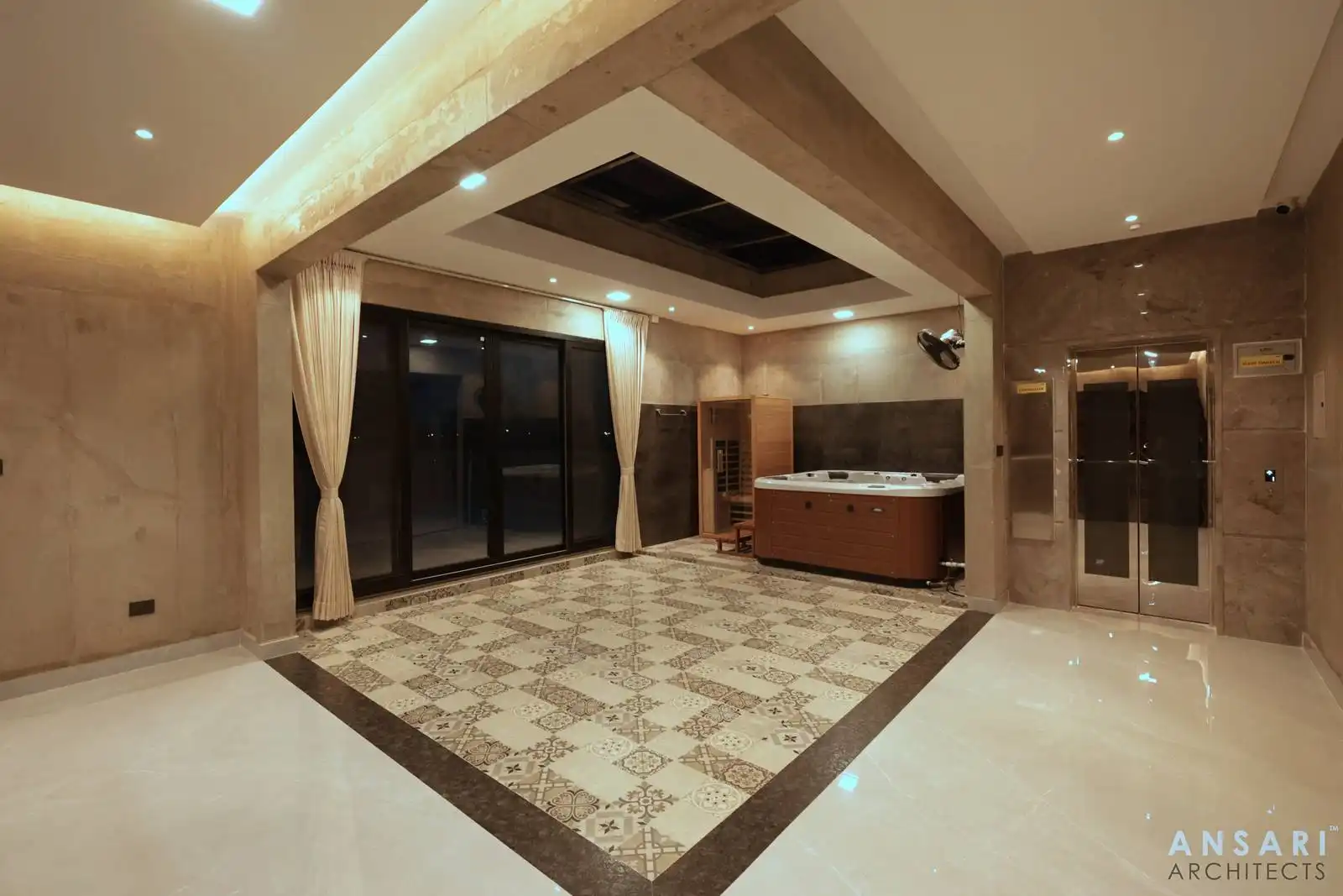 Indoor spa room featuring patterned tile flooring, a wooden sauna, jacuzzi tub, large glass doors with cream curtains, beige walls, and a stainless steel double door.