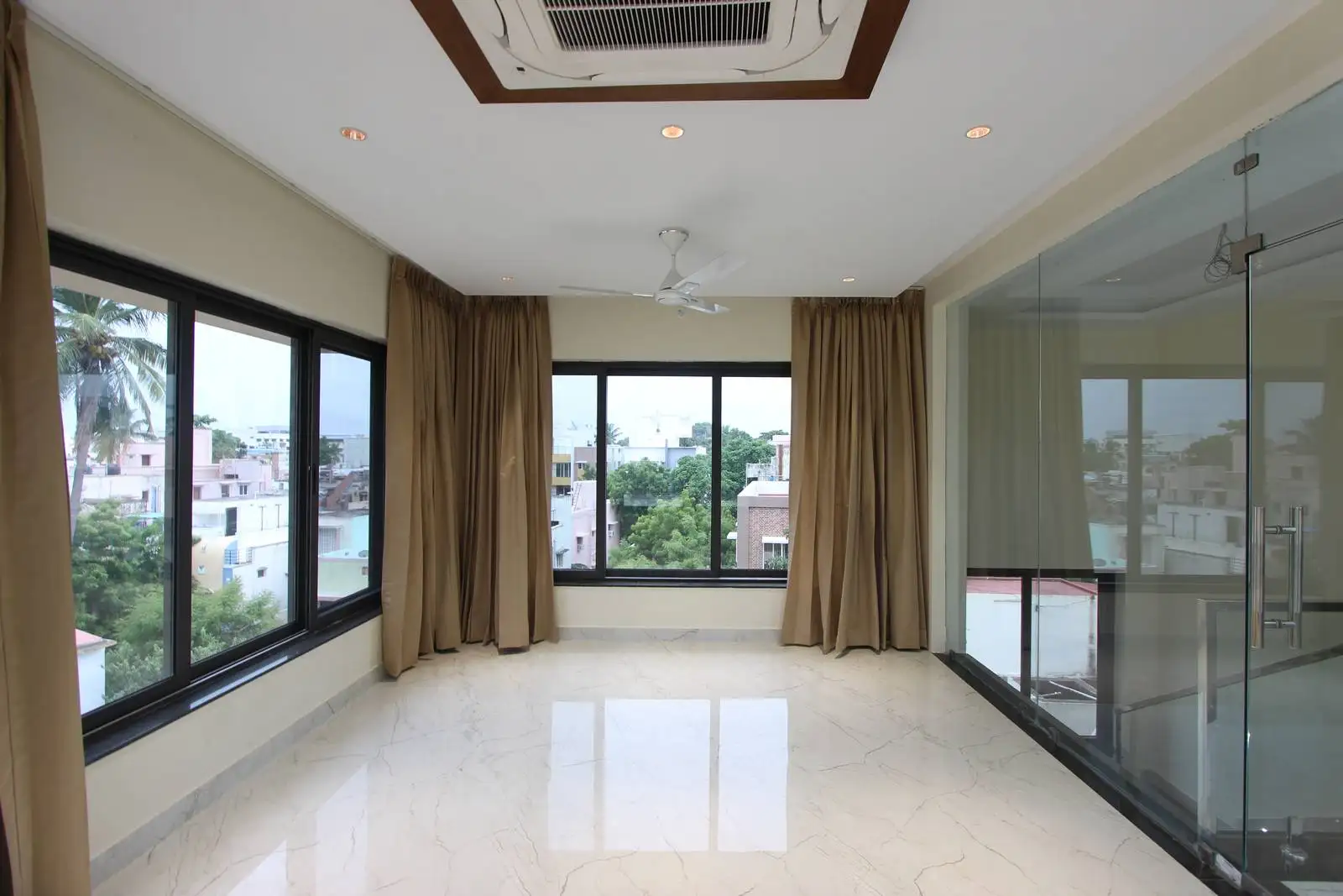 A flexible third-floor space with floor-to-ceiling curtains and an open layout, providing use as a home office, lounge, gym, or meeting area—easily adaptable for multiple functions.