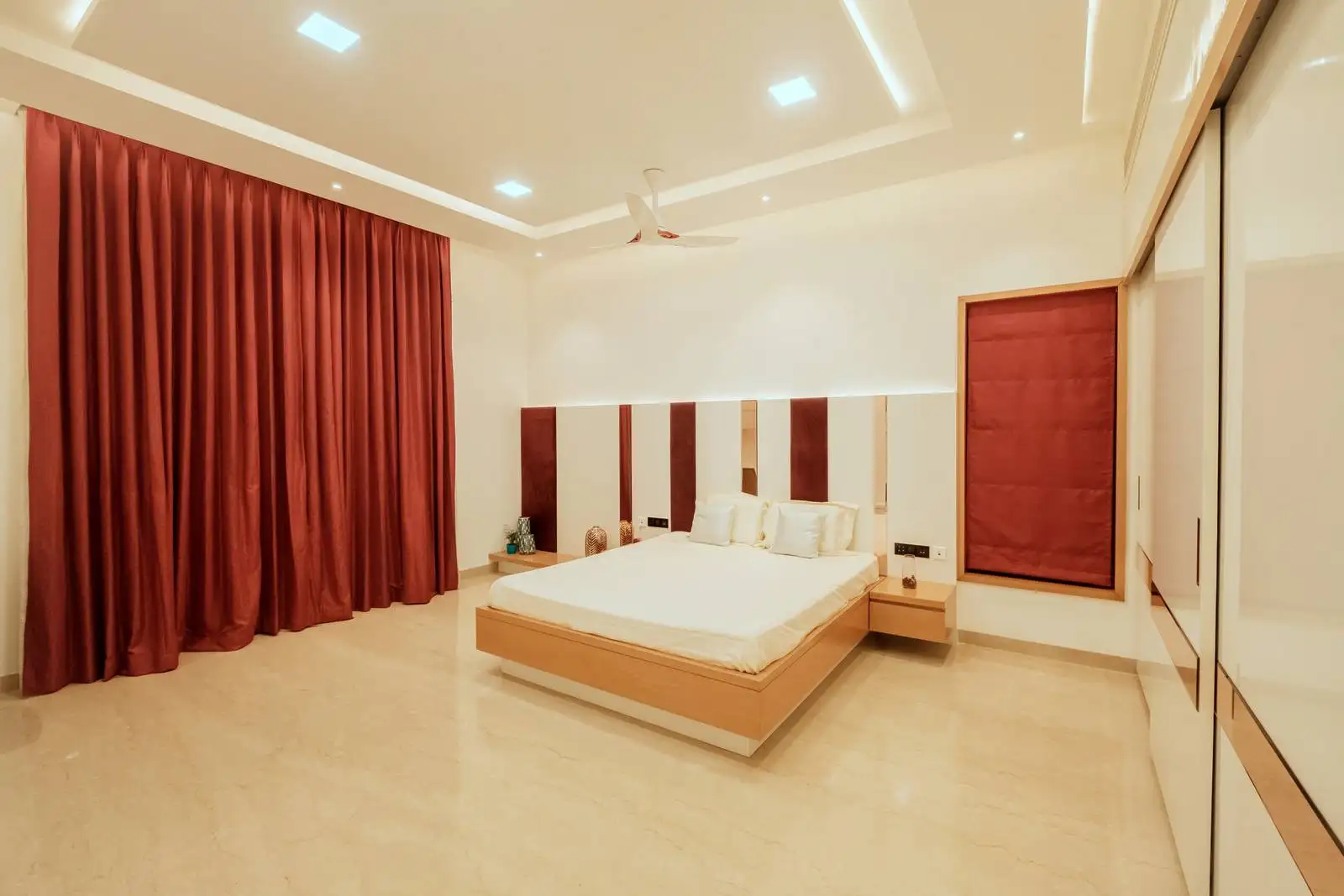 The bed is centrally placed against a feature wall, flanked by two floating nightstands, creating a balanced and harmonious layout.