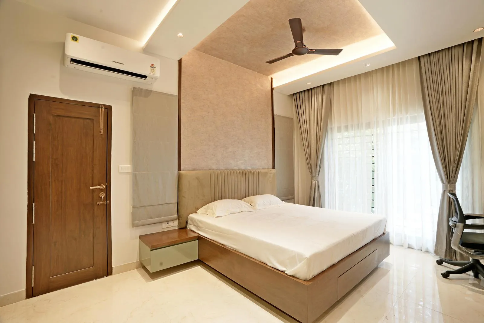 The master bedroom ( 12'0" x 17'0" sq.ft ) features a rectilinear layout with a central bed against a textured feature wall, complemented by teak wood furnishings and cream marble flooring. Large sliding doors, soft beige curtains, and recessed ceiling lighting enhance natural light, spatial depth, and functional flow.