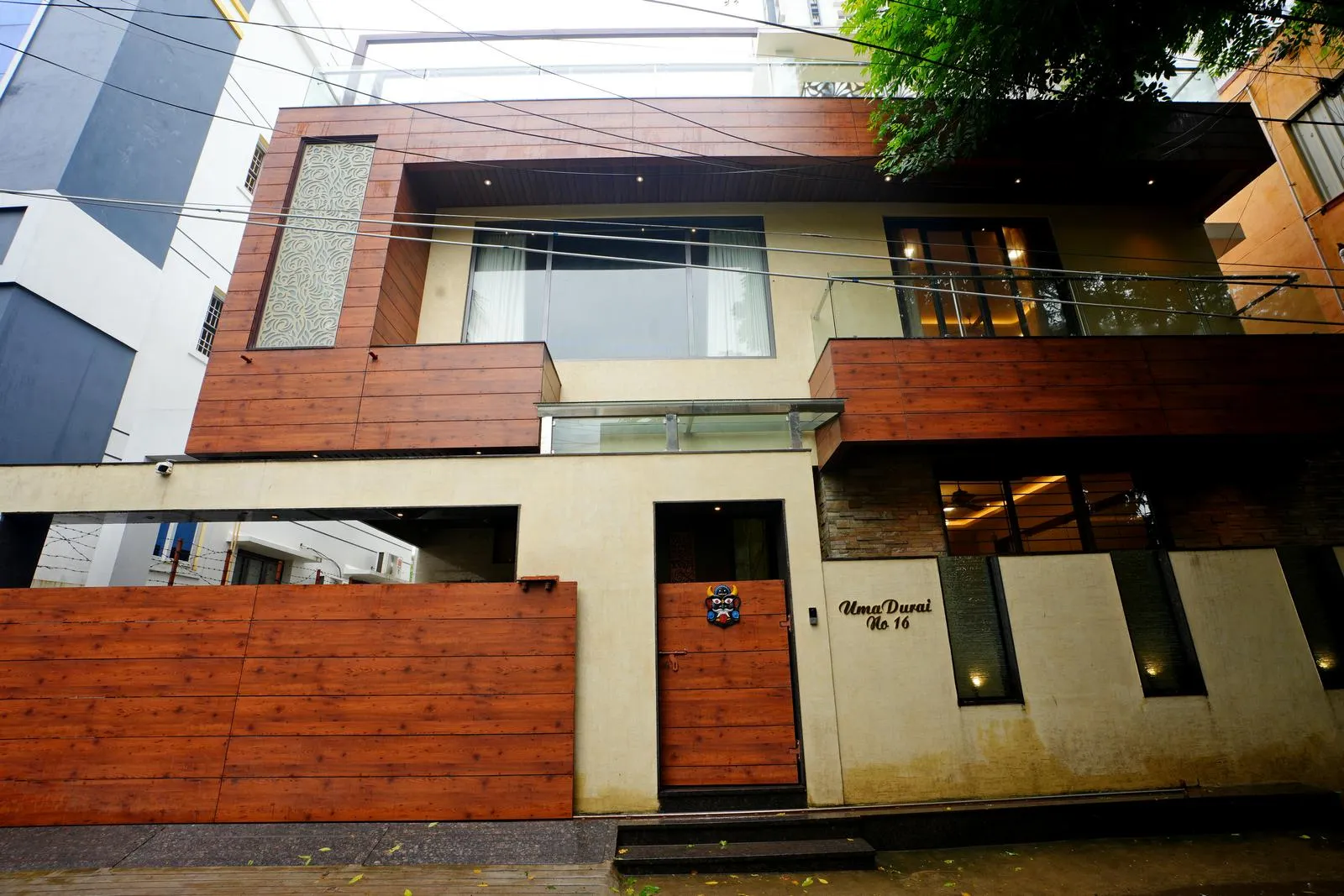 The facade features horizontal massing and asymmetrical rectilinear volumes, creating depth and visual interest. Balconies and glazing add transparency, while upper-floor projections with recessed lighting enhance a dynamic, floating effect.