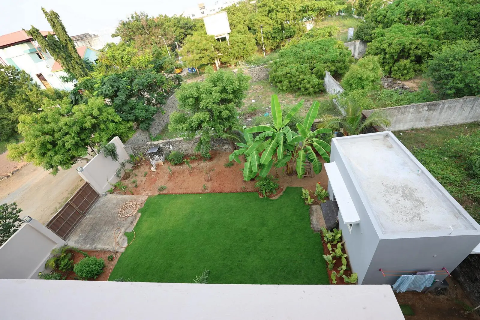 The rectilinear courtyard is a central open space linking the surrounding structures. A lush lawn, layered plants, and private walls create a calm, balanced outdoor area.