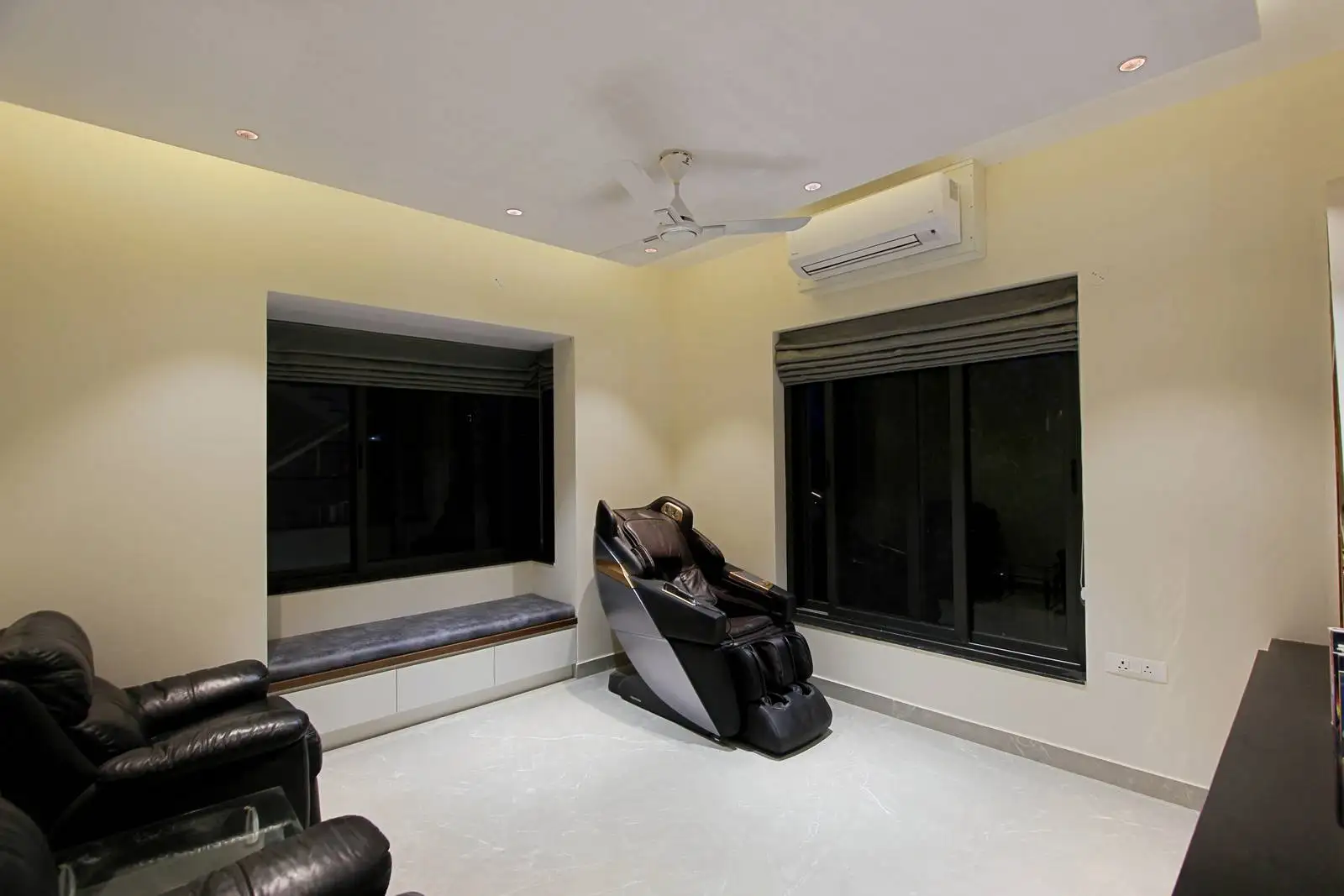 Large windows bring in natural light and connect the interior to outdoor views. The open family area offers flexibility for daily activities, while a centrally placed massage chair emphasizes comfort and well-being.
