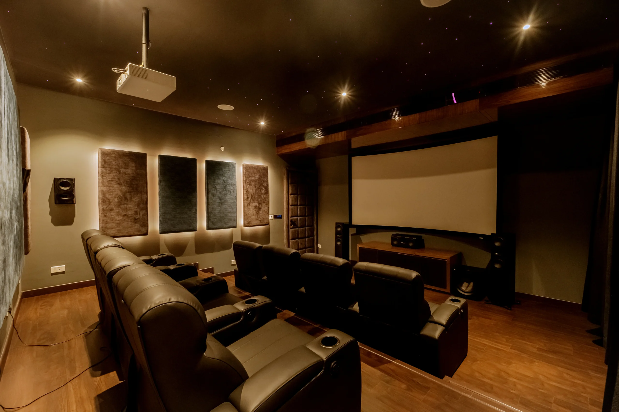 Dedicated home theater with tiered leather recliners in a windowless, sound-optimized space for an immersive cinematic experience.