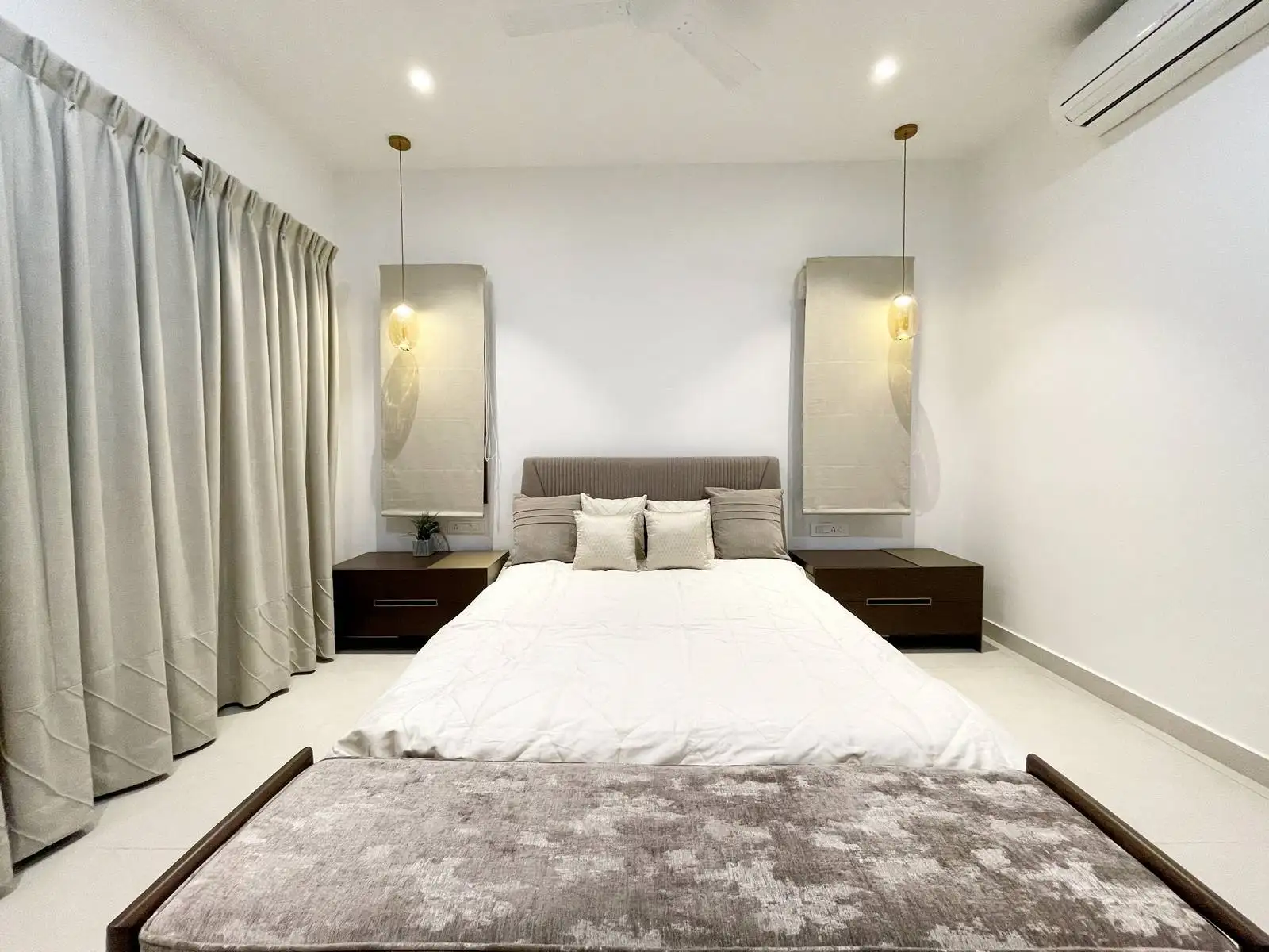 Bedroom Two features a strategically placed window that enhances natural light, ventilation, and spatial balance. Slim-framed glazing and neutral full-height curtains maintain privacy while complementing the minimalist design.