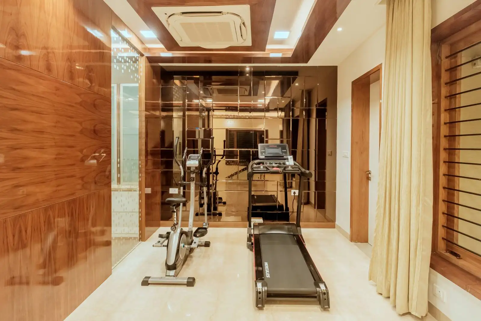 A compact third-floor gym designed for personal fitness, featuring side-by-side cardio equipment and efficient use of available floor space.