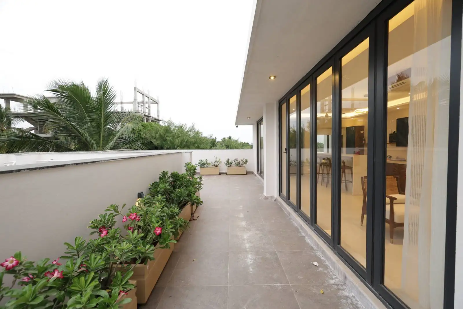 Direct access from the interior via large glass doors for seamless flow. Parapet wall for safety and privacy.