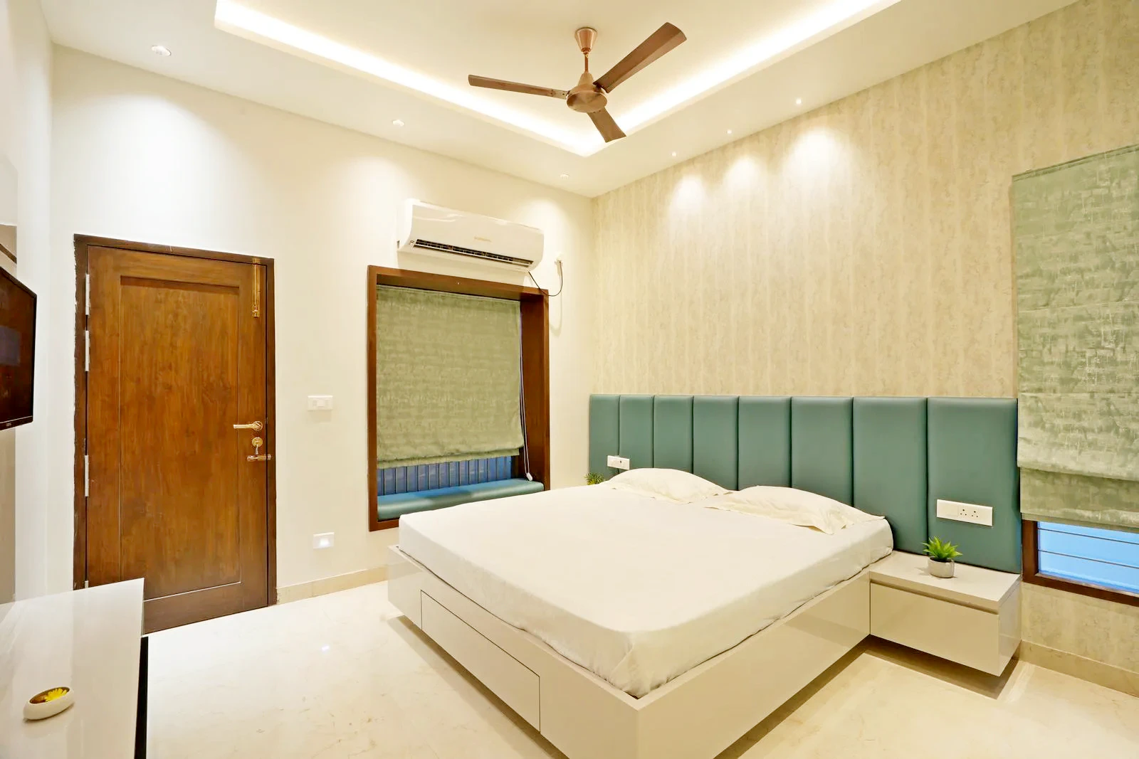 Guest Bedroom ( 12'0" x 13'0" sq.ft ) a rectilinear layout with a central bed, handle-less wardrobe, and floating TV unit maximizes space and balance. Layered lighting, soft tones, and natural materials enhance comfort, proportion, and modern minimalism.