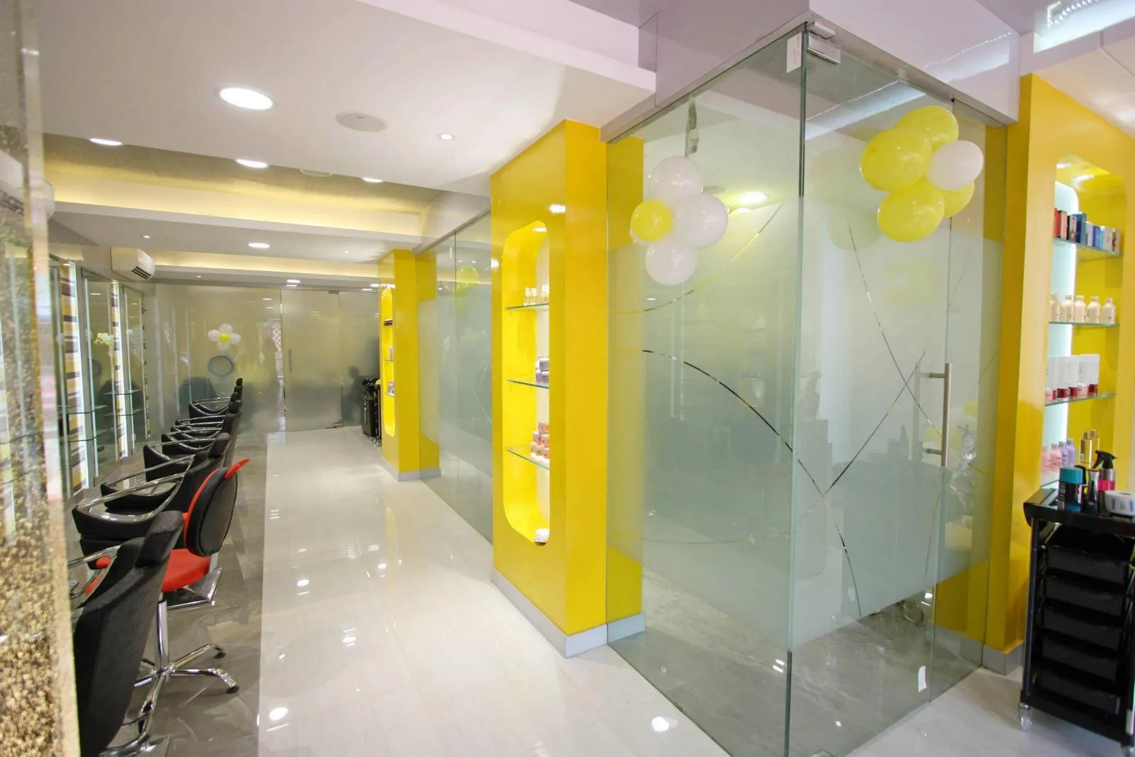 Yellow wall panels contrast with neutral floors and ceilings, while recessed glass niches with LED lighting display products stylishly. The design combines bold color with functional, attractive storage.