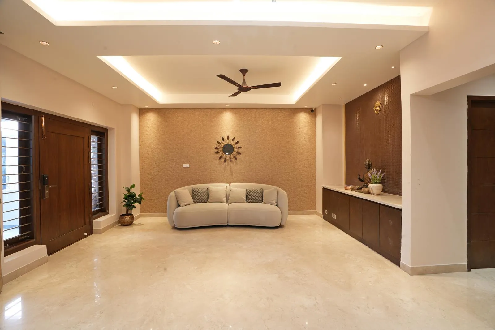 The Lobby area ( 24'0" x 15'0" sq.ft ) is a welcoming transitional space featuring a central curved seating arrangement, polished beige marble flooring, and warm wooden accents. Symmetry, integrated storage, and layered lighting create a calm, functional, and visually appealing entry environment.