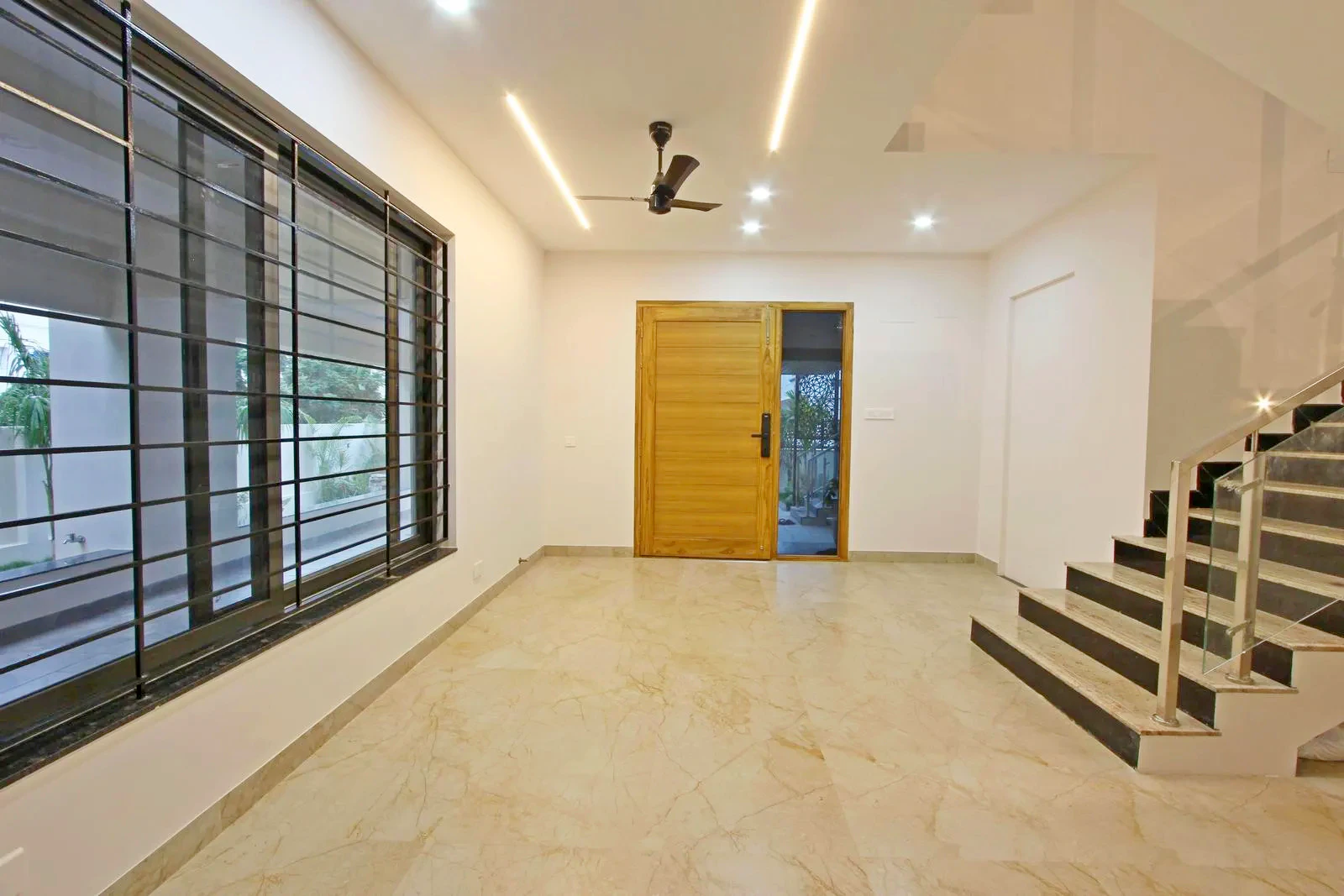 The aligned doorway establishes a clear visual axis from entrance to staircase, enhancing spatial clarity. The lobby serves as a central hub, with a side-wall staircase that maintains openness and efficient circulation.