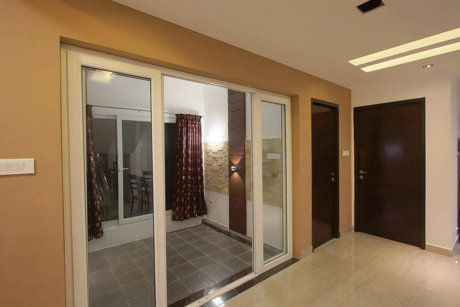 The sitting area, framed by full-height glass partitions, connects visually to the corridor while maintaining privacy and acoustic control. Its double-height design creates a bright, semi-private retreat that defines the space within the open-plan layout.