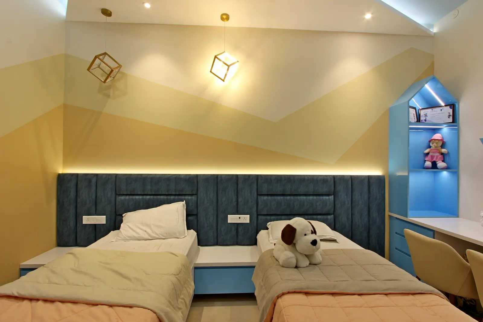 This modern kids’ bedroom features a stylish and cozy design with twin beds separated by a sleek white nightstand. 
