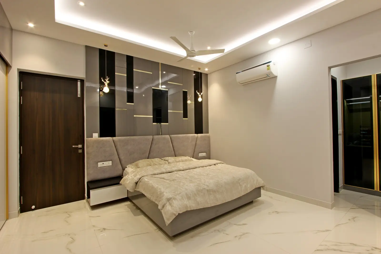 The ceiling features recessed lighting and a sleek fan, while glossy wardrobes and air conditioning enhance comfort, creating a stylish and functional space.

