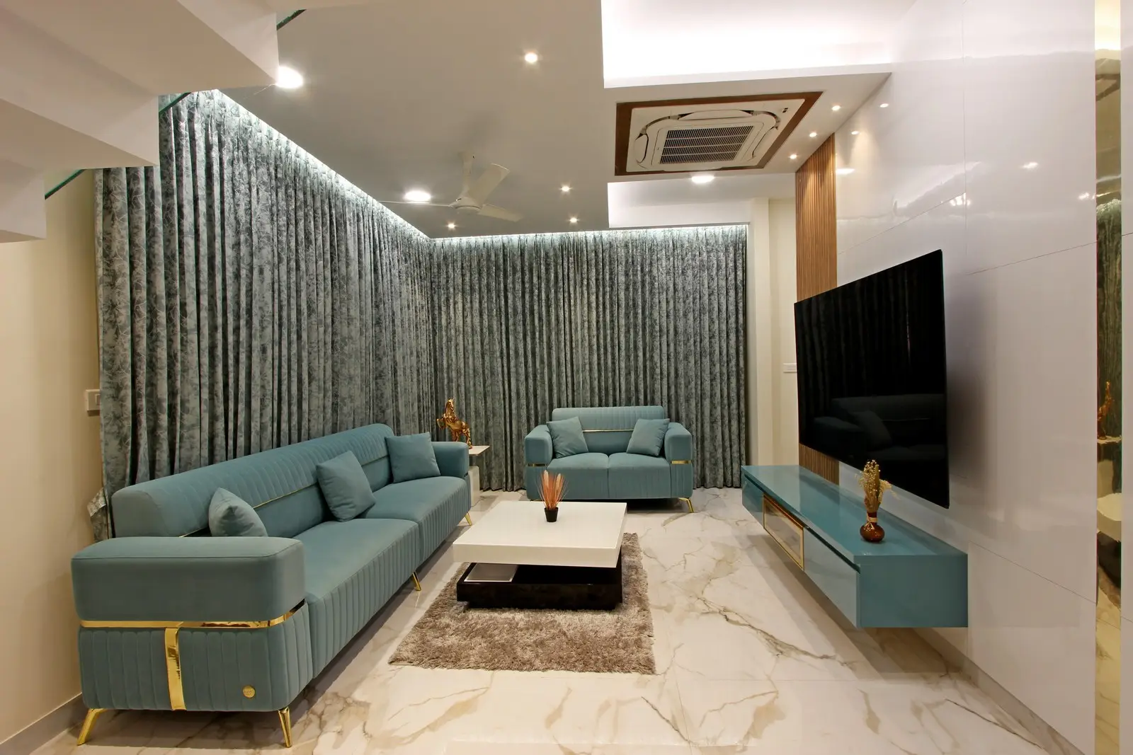 Featuring polished marble flooring, a sleek wooden door, golden wall panels, and a refined console with floral decor, this entryway exudes modern sophistication.