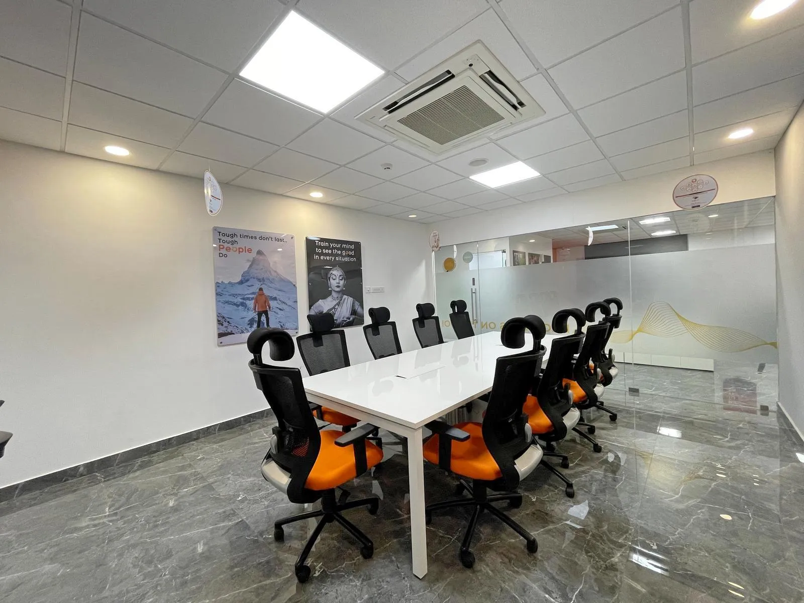 The executive boardroom features a modern design with a sleek laminated table, ergonomic chairs, and polished grey marble flooring. Frosted glass partitions, acoustic ceilings, and integrated lighting create a professional, functional, and visually elegant corporate space.