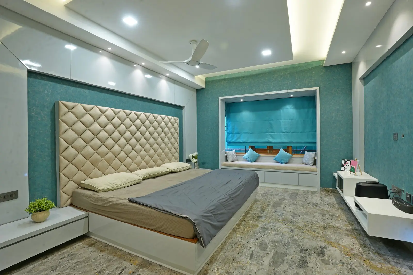 Second Floor -This master bedroom features a refined teal theme, a super king-size bed, elegant paneling, and an 8-foot seating window that brings abundant natural light.