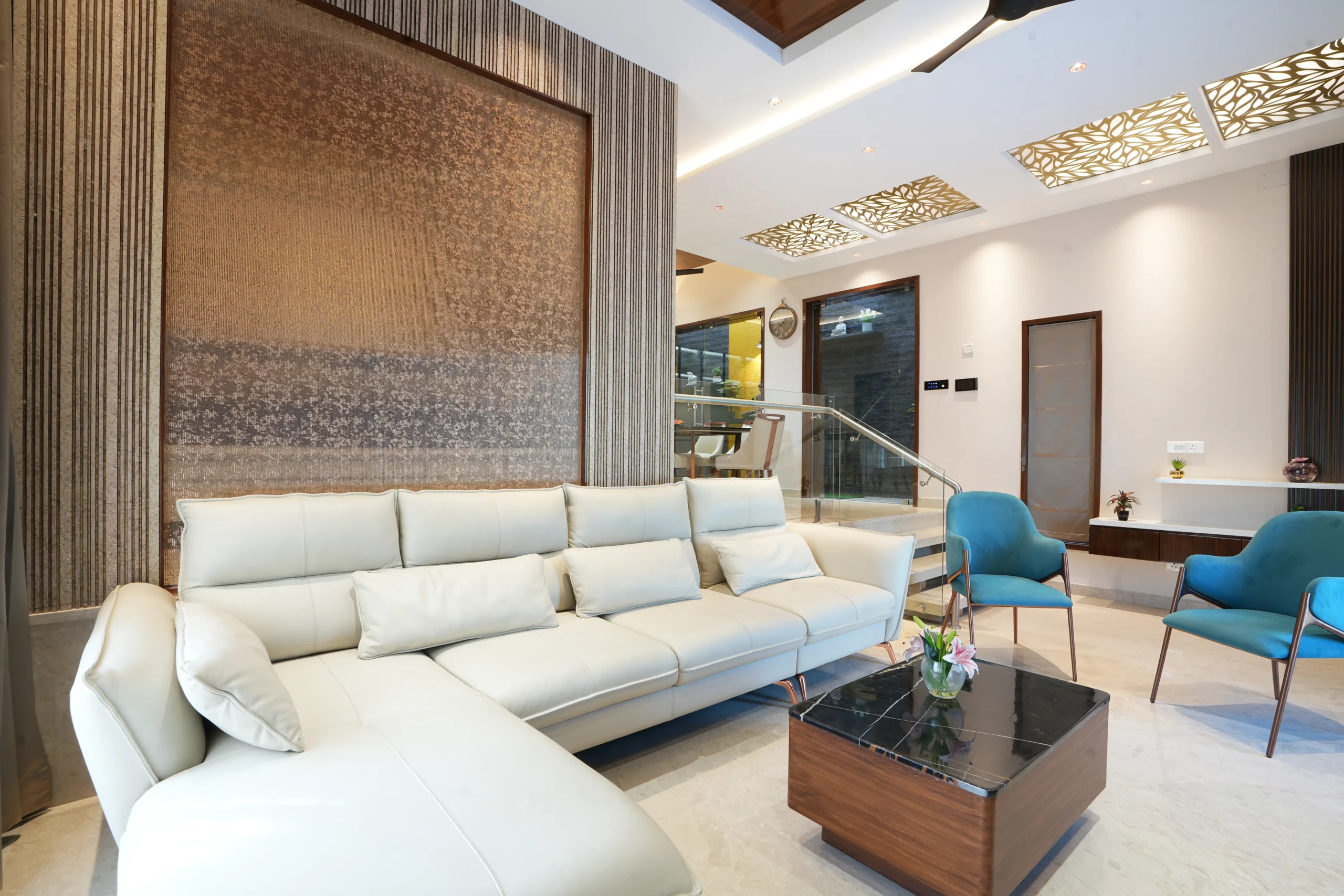 First Floor - This living room highlights a refined modern design with a cream-toned L-shaped leather sofa, a sleek wooden coffee table, and elegant recessed lighting.
