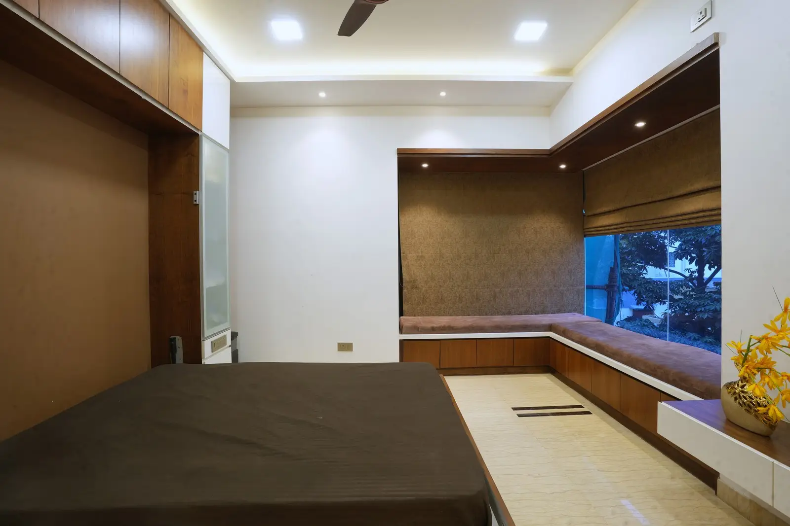 The highlight of the room is the L-shaped sitting window with fixed glass, flooding the space with natural light and providing a cozy corner for reading, relaxing, or enjoying outdoor views.