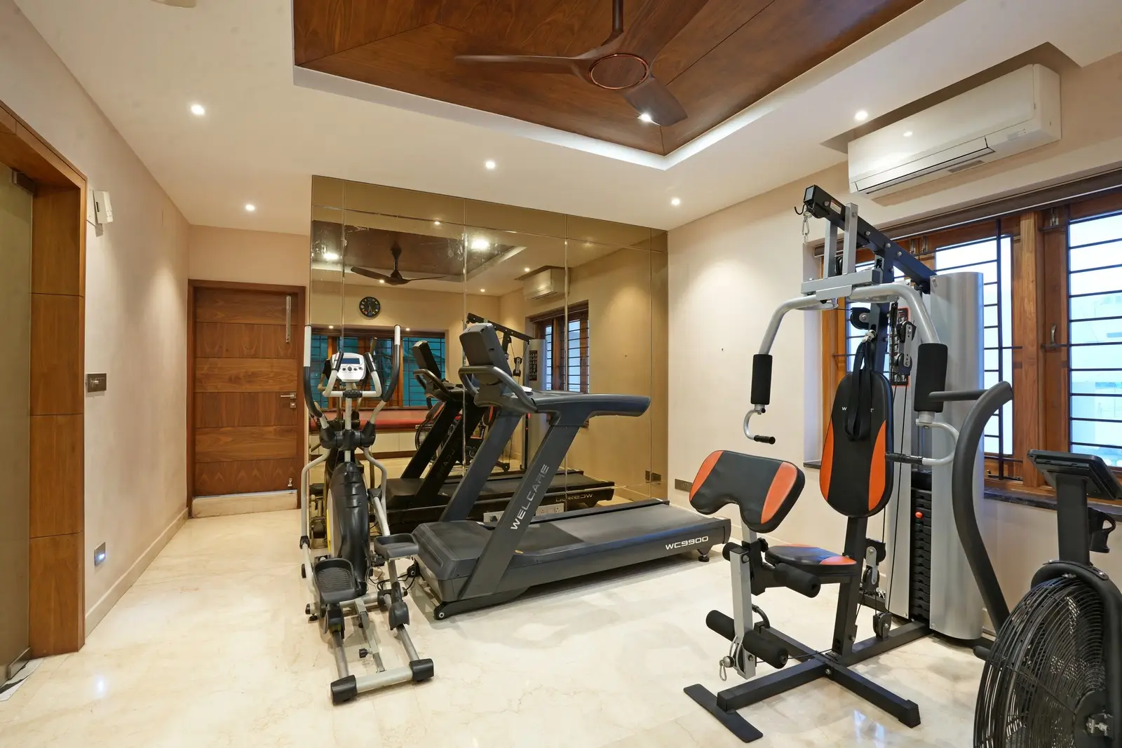 A full-wall beveled copper mirror, sitting window, and attached special room add depth, light, richness, and versatility to the gym space.

