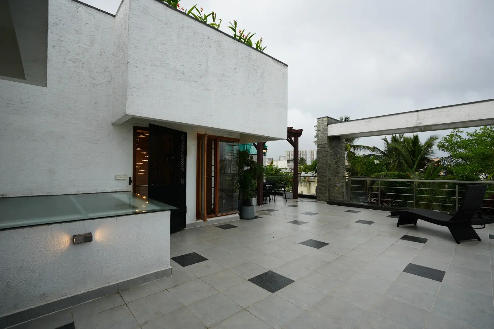 Terrace seamlessly blends elegance and functionality, with durable WPC finishes, sleek grey tiles, decorative grill panels, planter boxes, and vibrant natural greenery.