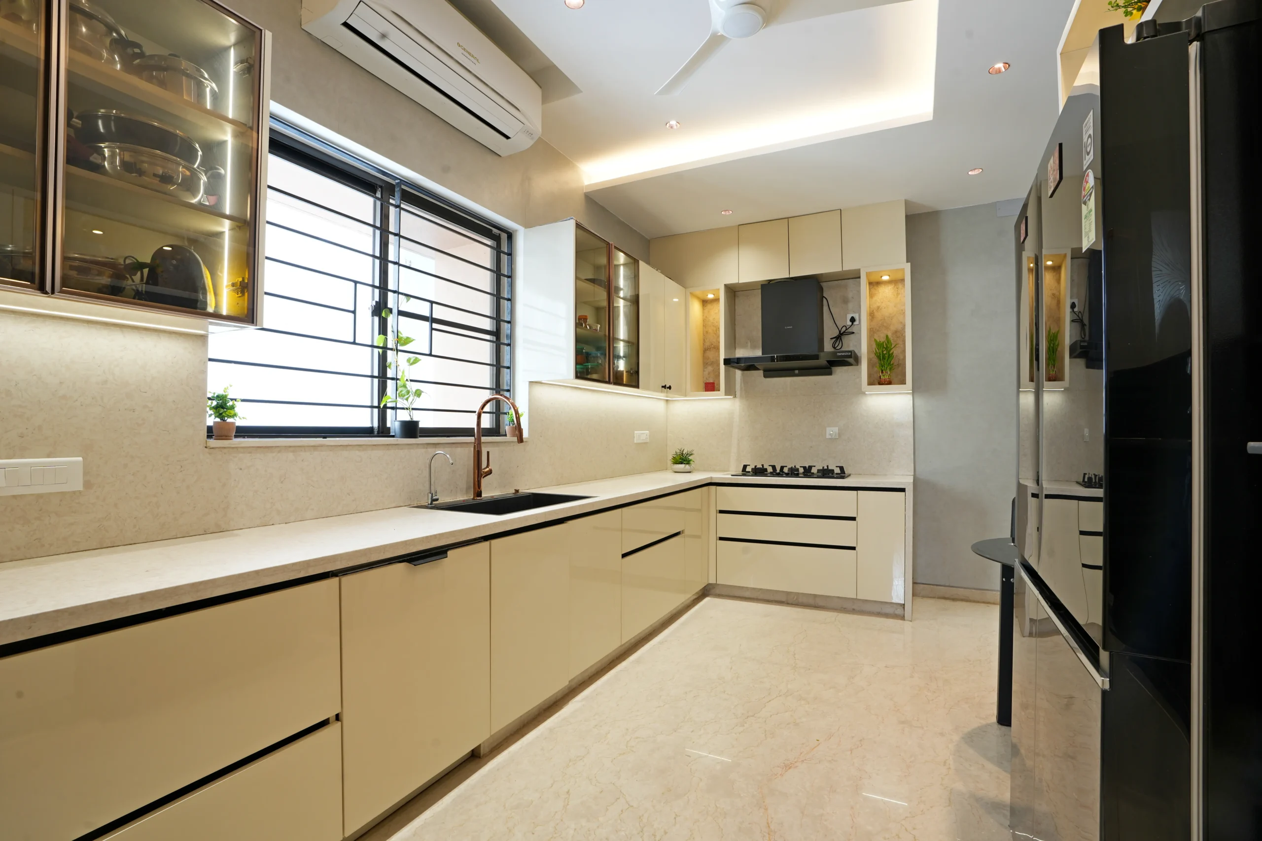 Natural light enhances the textured grey walls, black sink, and copper faucet, while recessed lighting and wooden accents add warmth and elegance.