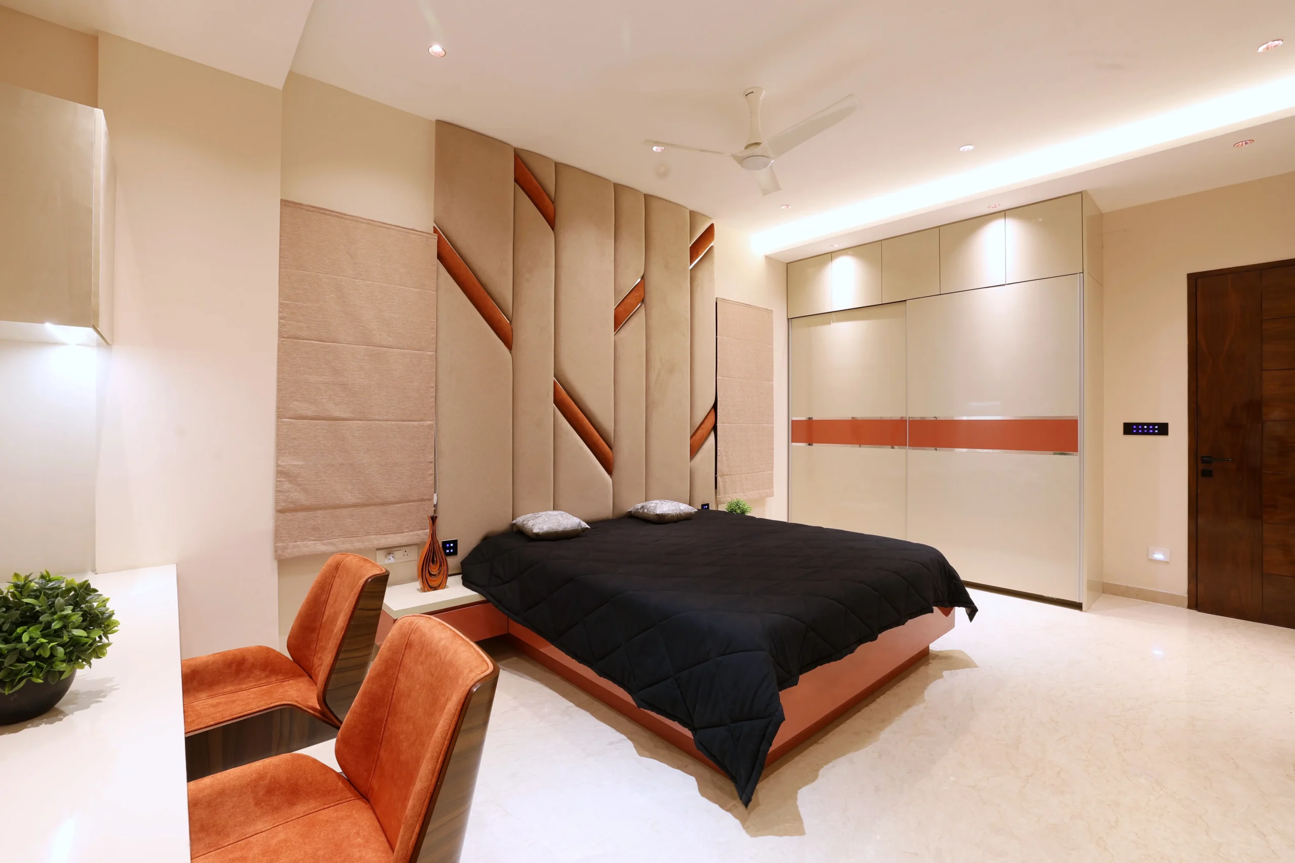 Polished cream marble flooring, recessed and cove lighting, Roman blinds, and a sleek ceiling fan enhance comfort, brightness, and the bedroom’s sophisticated, serene ambiance.