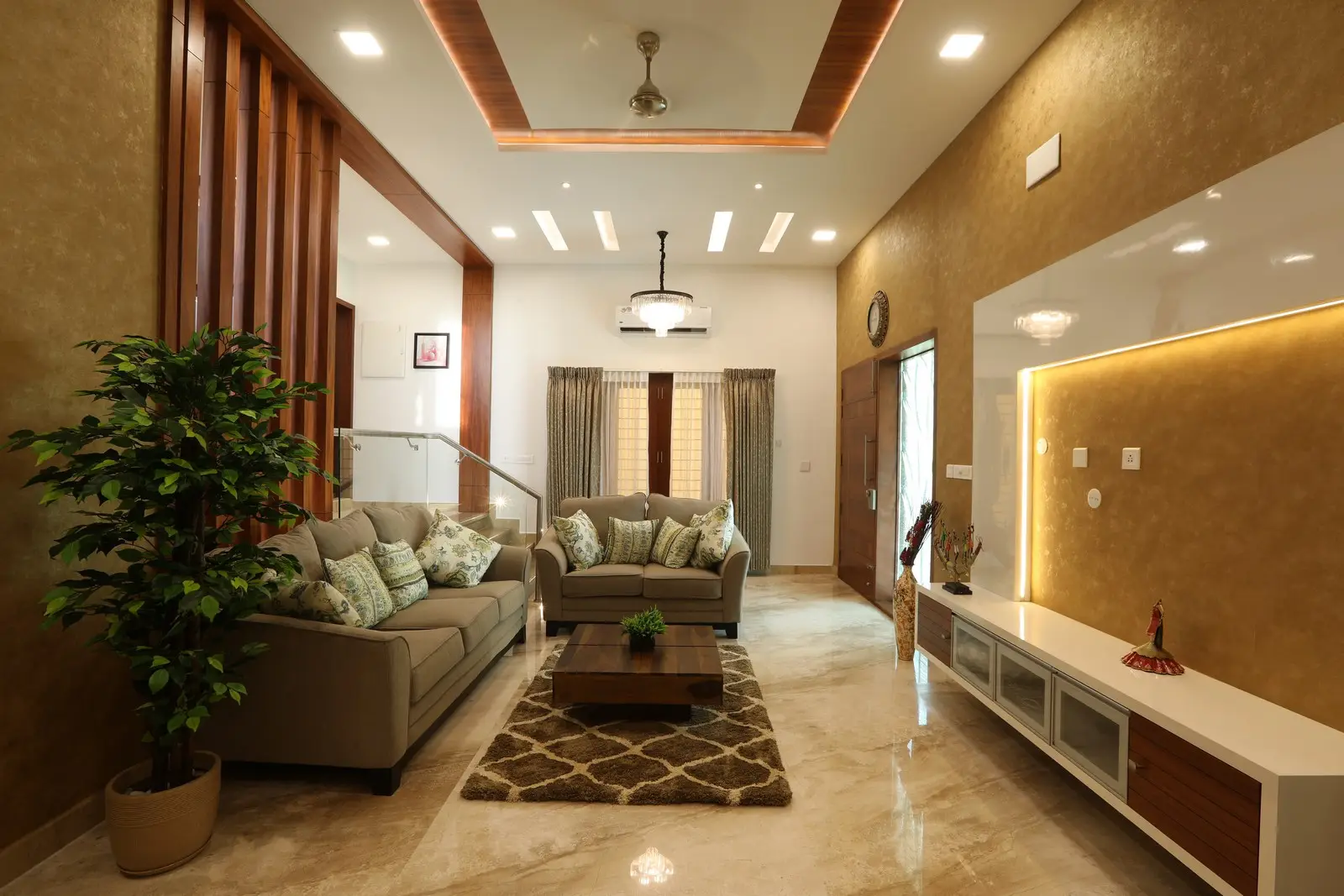 A beautifully designed living room features warm lighting, neutral walls, elegant furniture, and marble flooring, creating a luxurious and comfortable space for relaxation and gatherings.

