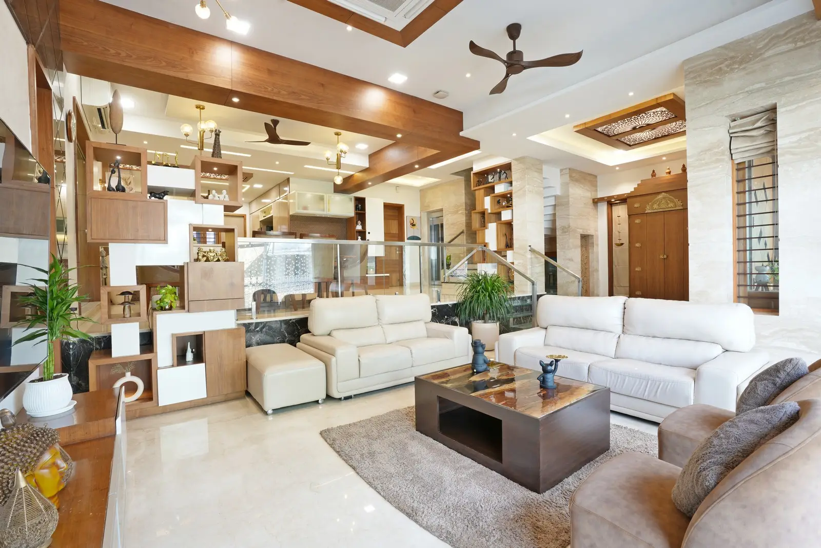 The double-height living room features brown leather sofas, a laminated glass window, and cross-ventilation, creating a bright, airy, and open environment.
