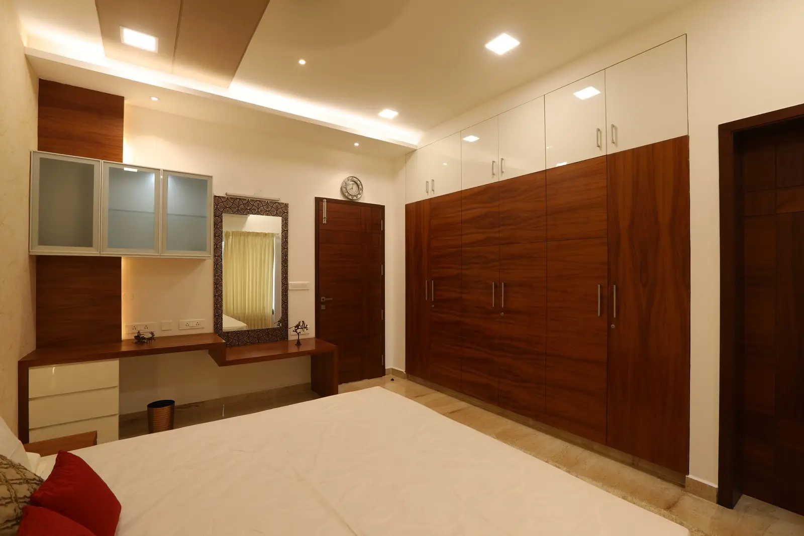 Warm lighting enhances the room’s wooden wardrobes, sleek dressing area, and neutral walls, creating a clean, inviting, and well-balanced modern bedroom interior.creating a clean, inviting, and well-balanced modern bedroom interior.


